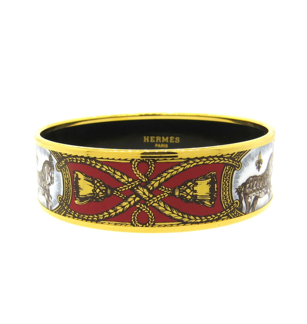 A base metal bracelet covered in printed enamel with gold plating.  Crafted by Hermes, the bracelet measures 19.7mm in width and has an interior diameter of 62mm.  The weight of the piece is 36.4 grams.