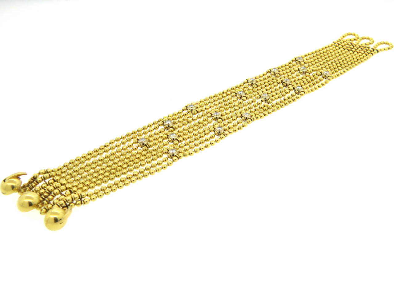 18k gold multi strand bracelet, crafted by Cartier for Draperie de Decollete collection, adorned with approximately 0.85ctw in diamonds. Bracelet is 7 1/2" long and 25mm wide. Marked Cartier, 921322, 750. Weight of the piece - 56.1 grams