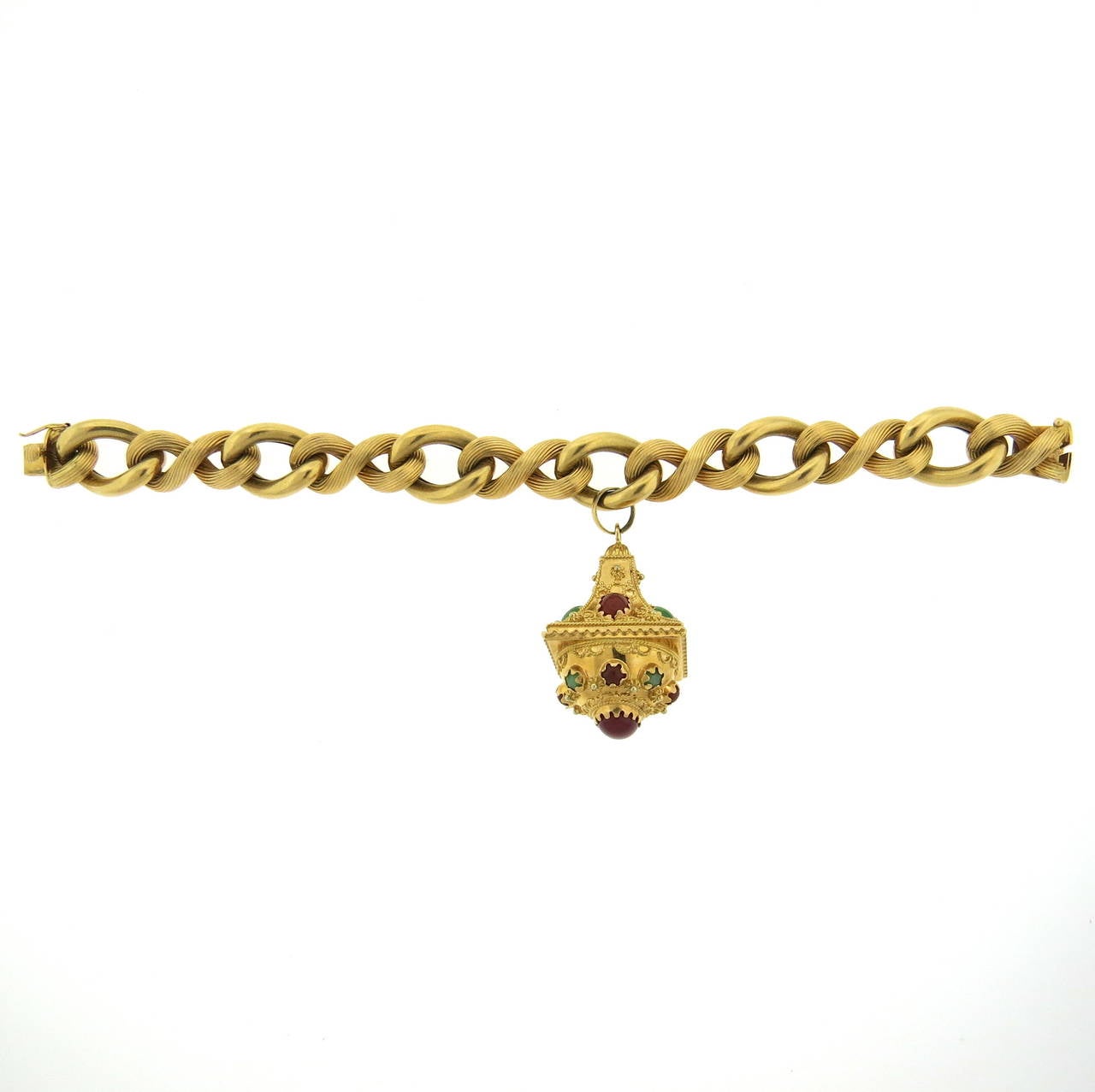 An 18k yellow gold bracelet with a charm set with nephrite and carnelian.  The bracelet measures 7.75