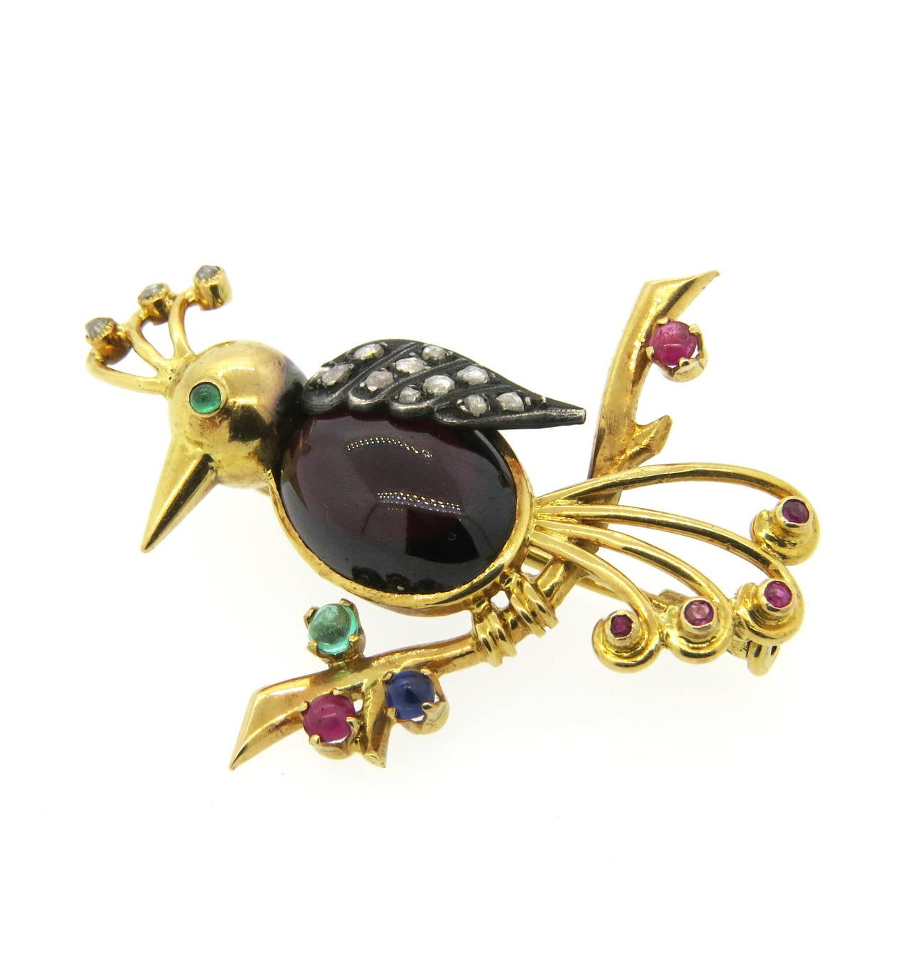 Antique Continental 18k gold bird brooch, decorated with 14.5mm x 11mm garnet cabochon, rubies, emeralds, sapphires and rose cut diamonds set in silver. Brooch measures 46mm x 40mm. Weight of the piece - 12.4 grams