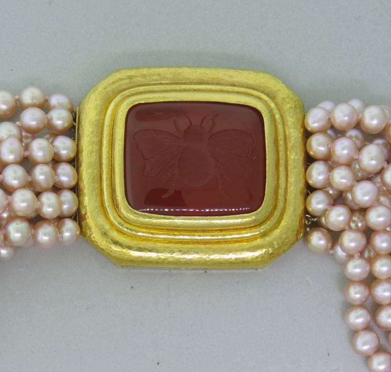 A beautiful 5mm - 6mm multi strand pearl necklace with an 18k yellow gold clasp, featuring a carnelian intaglio.  The clasp measures 40mm x 45mm.  The length of the piece is 17