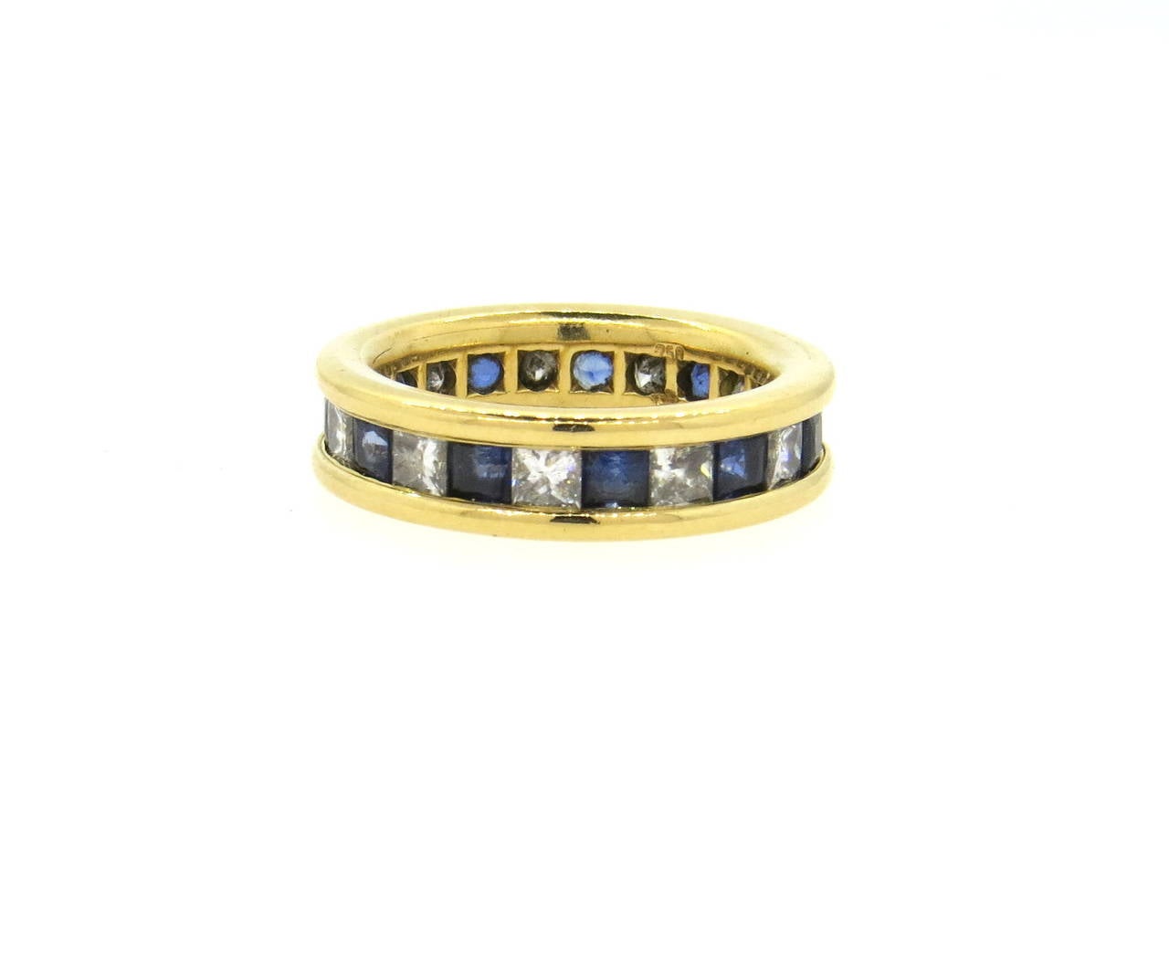 18k yellow gold band ring, crafted by Gubelin, set with approximately 1.20ctw in G/Vs diamonds and square cut blue sapphires. Ring is a size 6, ring is 5.5mm wide. Marked with Gubelin mark and 750. Weight of the piece - 7.6 grams