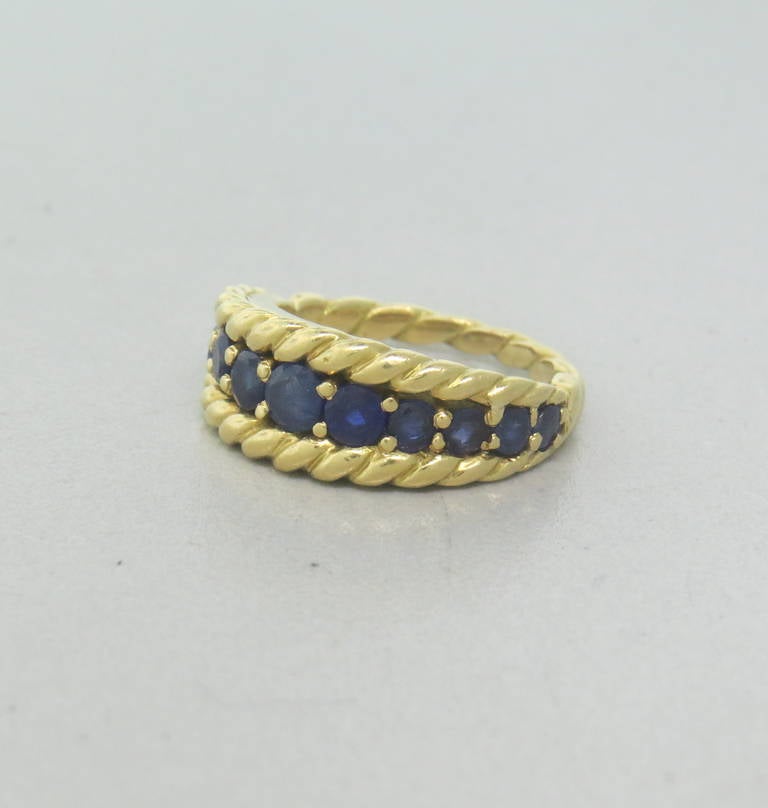 1980s Tiffany & Co 18k Yellow Gold Sapphire Band Ring in a size 5.25.  The ring is 8.2mm wide at the widest point and weighs 8.1 grams.
