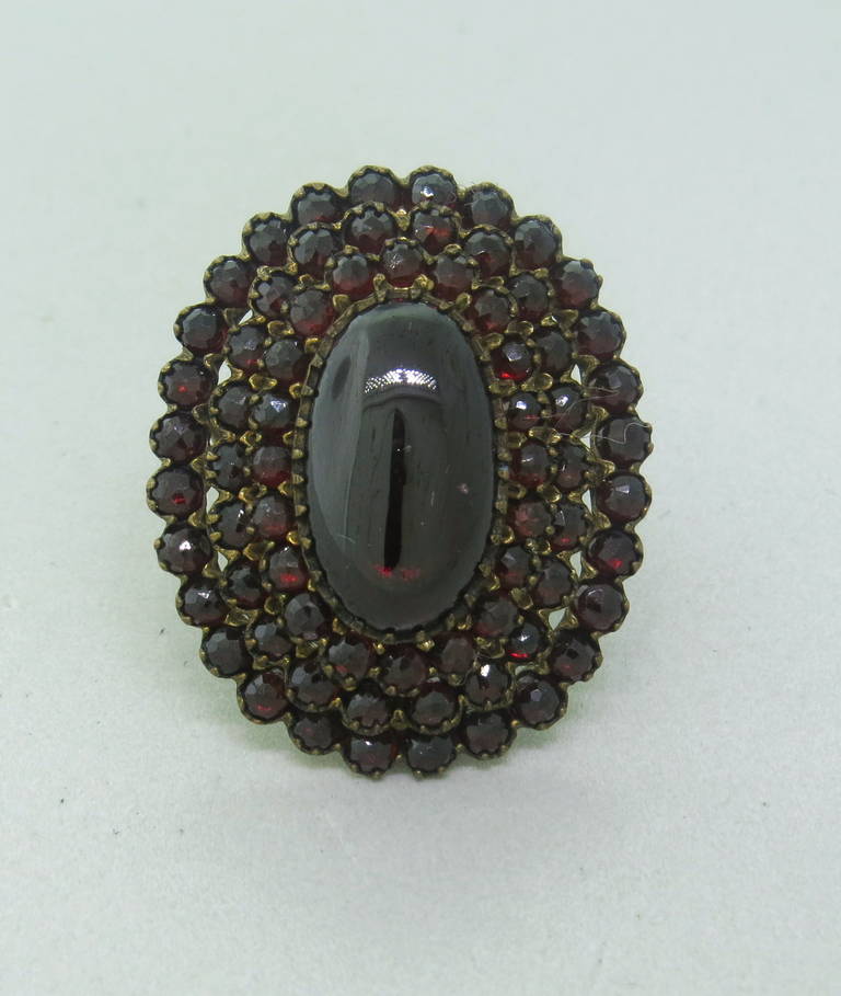 An antique low carat gold / gilt silver ring set with bohemian garnets.  The top of the ring measures 37mm x 30mm.  The ring is a size 7 and weighs 13.7 grams.