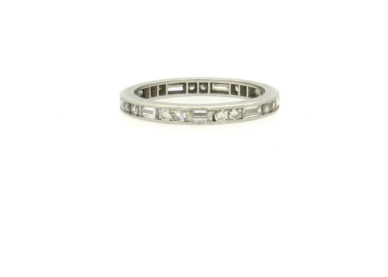 Classic platinum wedding band ring, set with a full circle of alternating round and baguette cut diamonds - total of approximately 0.60ctw H/VS. Ring is a size 6 1/2 and is 2.5mm wide. Weight of the piece - 3.4 grams