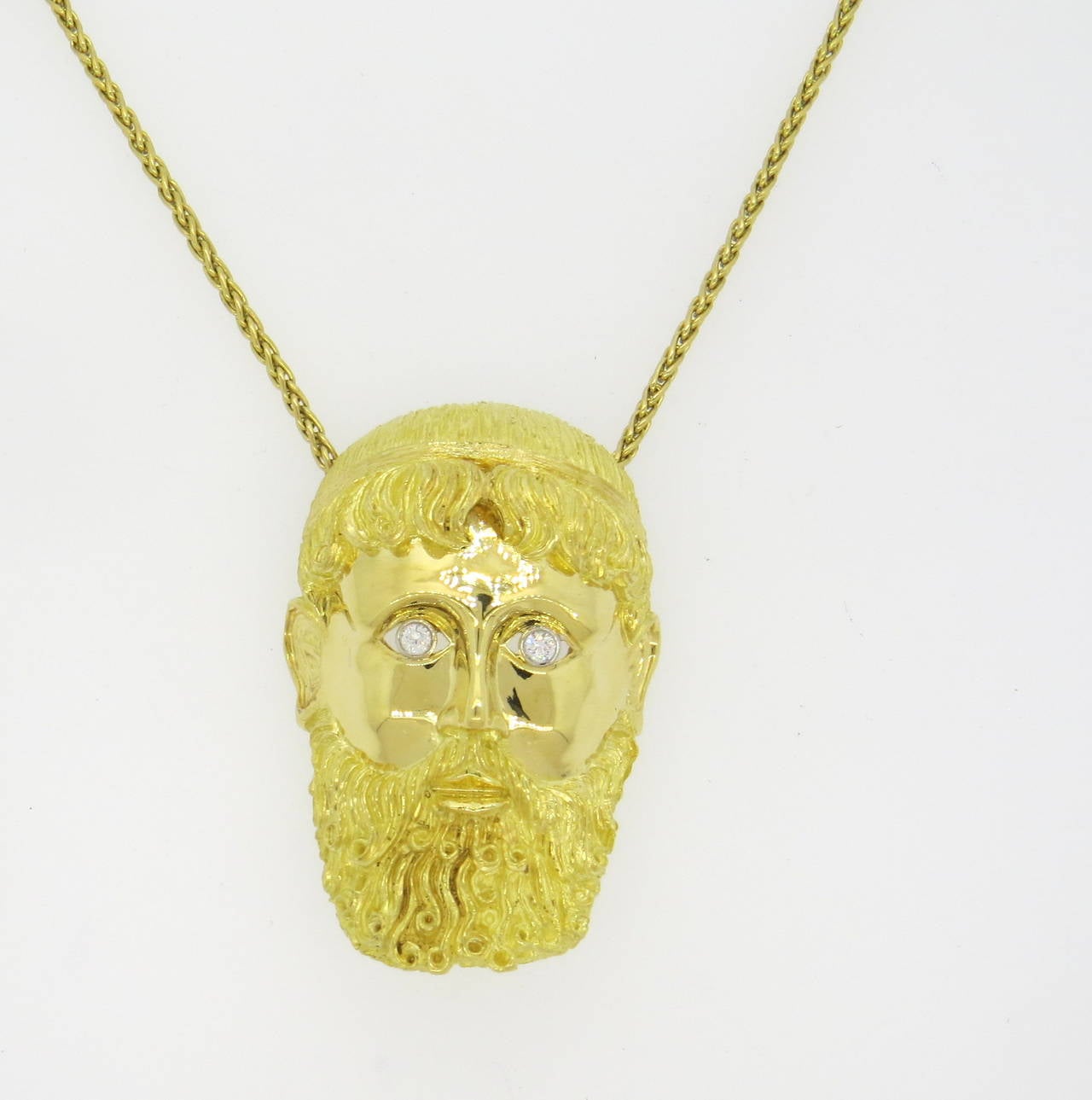 Impressive and large 18k gold brooch pendant,crafted by Henry Dunay , featuring a man's face with beard, crafted with two diamond eyes - approx. 0.30ctw G/VS. Pendant/brooch measures 67mm x 43mm. Marked 18k and Dunay. Weight - 69.7g. Chain is not