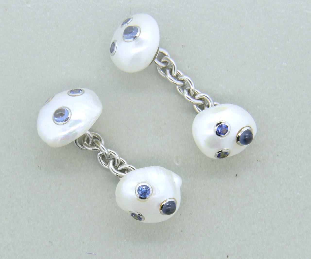 Pair of 18k white gold cufflinks, crafted by Trianon, featuring pearl top and blue sapphires. Tops measure approx. 12mm x 10mm. Marked Trianon and 750. Weight - 7 grams
Retail $4400