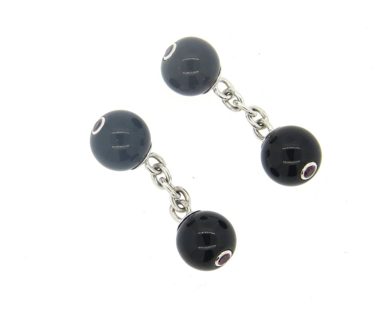 Pair of 18k white gold cufflinks, crafted by Trianon, set with onyx ball top and ruby gemstone in the center. Top measures 10mm in diameter. Marked with Trianon mark. Weight - 7.8 grams
Retail $2000