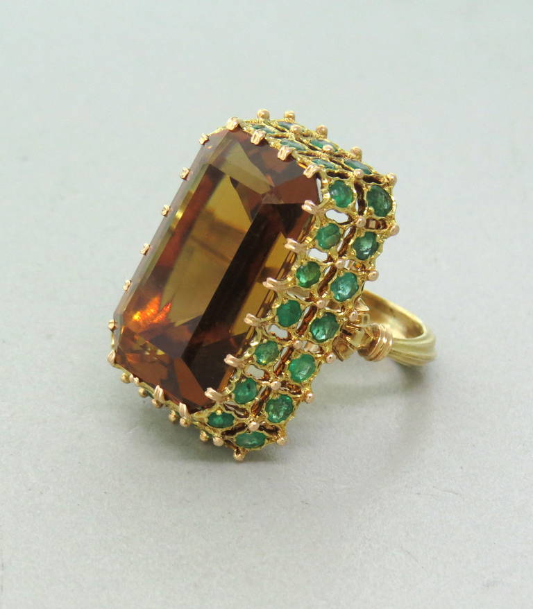 An 18k yellow gold ring by Buccellati Italy set with a citrine weighing approximately 29 carats and surrounded by emeralds.  The ring is a size 6.5.  The top of ring is 30mm x 21mm and the ring weighs 20.6 grams.