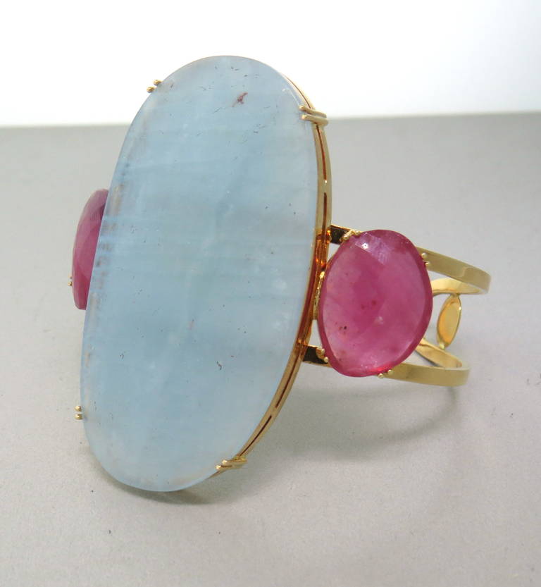 18k gold cuff with large 60mm x 33mm aquamarine with two 19mm x 15mm rubellites . Bracelet will fit up to 7