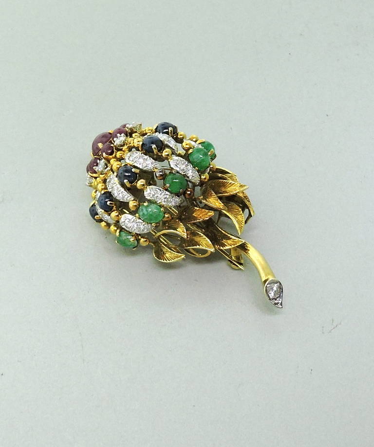 Remarkable 18K yellow gold clip brooch, circa 1960s. Brooch features approx. 1.50ctw of VS/G-H diamonds, 1.20ctw of ruby cabochons, 1.20ctw of Sapphire cabochons and approx. 1.40ctw of Emerald cabochons. Brooch measures 60mm x 32mm. Marked JGJLRY,