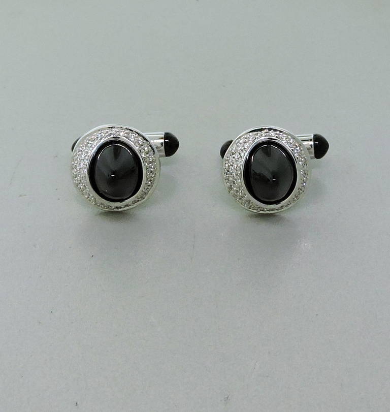 Ambrosi 18K white gold cufflinks featuring approx. 1.46ctw of diamonds and onyx and accent sapphires. Cufflink tops measure 16mm in diameter and 12.8mm high. Marked Ambrosi, 750. Weight - 21.8gr