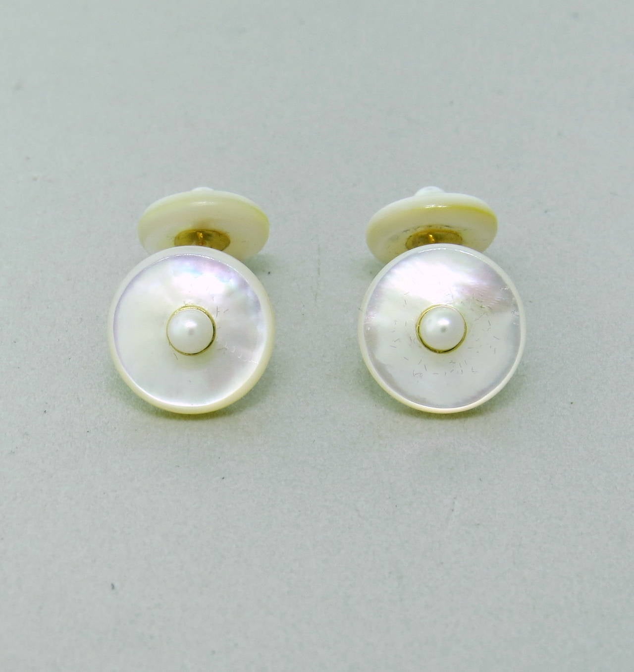 18k gold cufflinks by Trianon with mother of pearl top and pearl in the center. Top is 13.2mm in diameter, back is 11mm in diameter. weight - 5.6gr