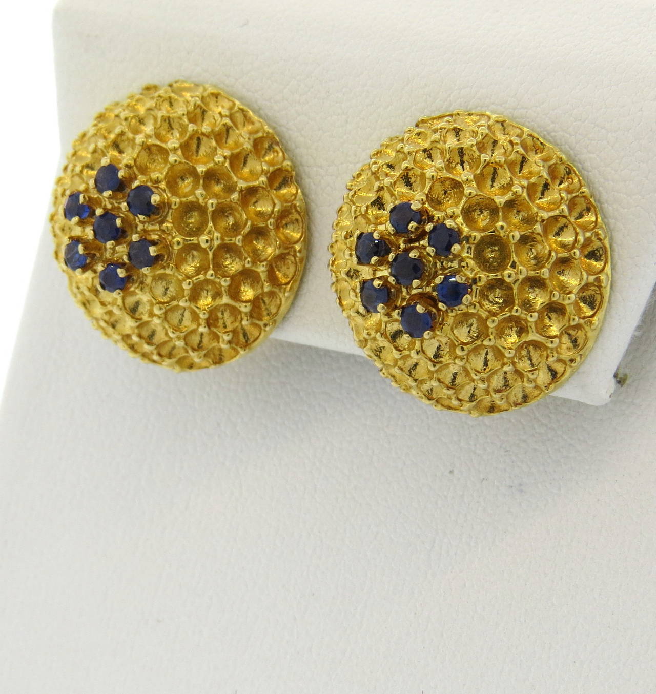 A pair of 18k yellow gold earrings set with sapphires.  Crafted in the 1970s, the earrings measure 20.3mm in diameter and weigh 18.7 grams