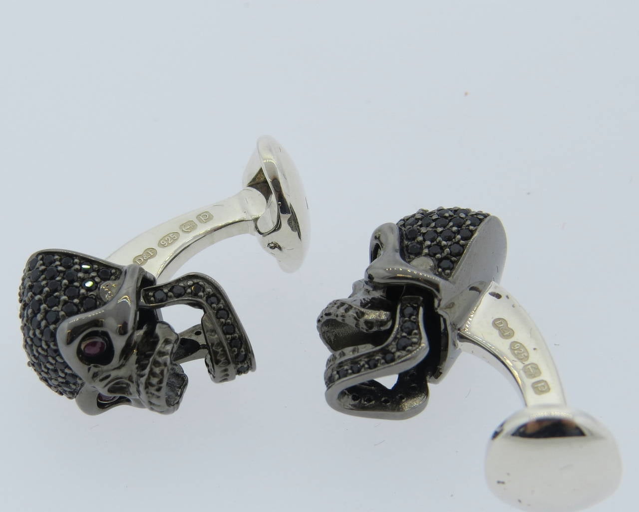 Brand new Deakin & Francis sterling silver skull cufflinks decorated with black spinel and rubies, features moving jaw and eyes. Come with original box and papers. Cufflinks measure 20mm x 12mm, weight - 19.0gr.
