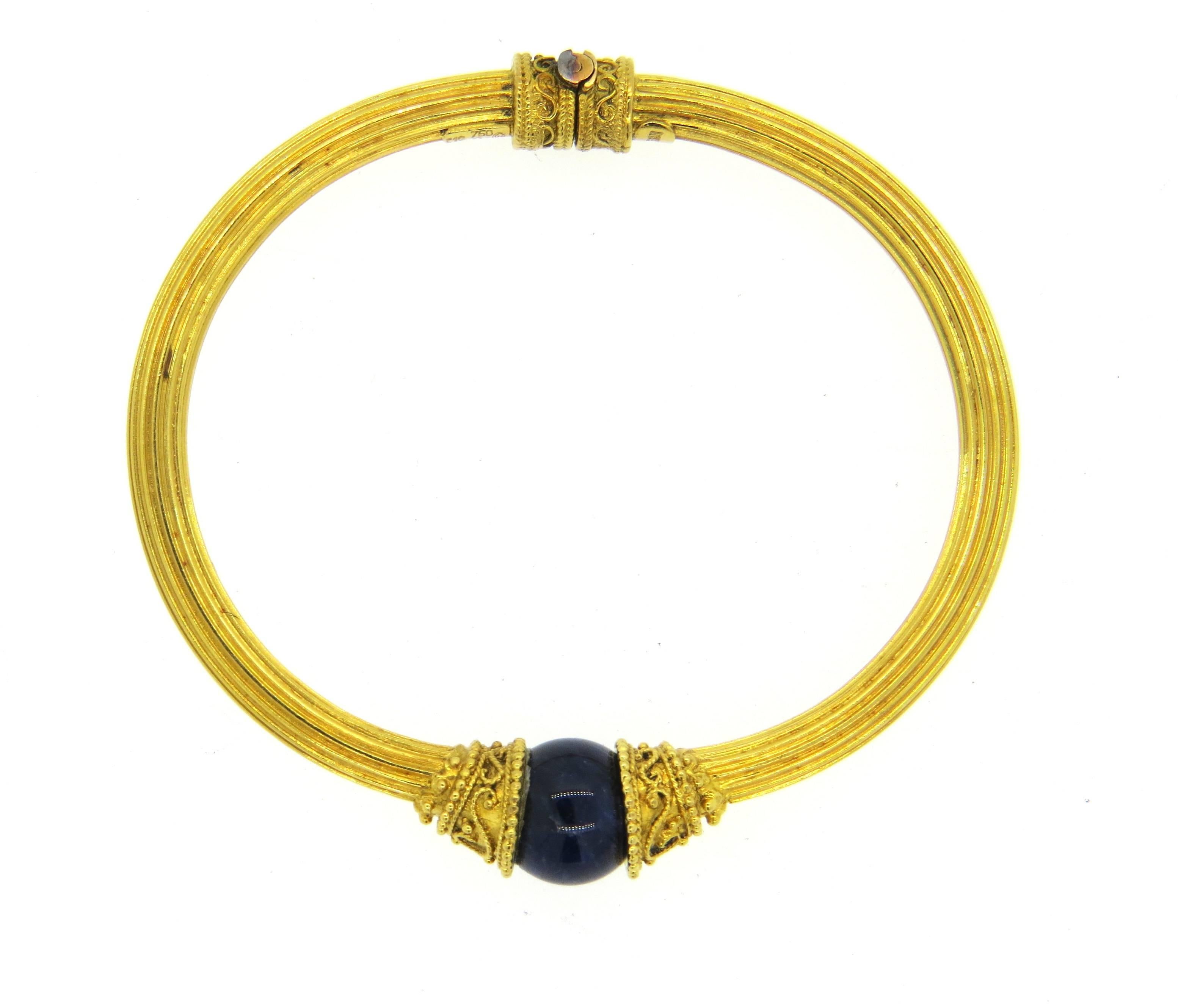 18k yellow gold bangle bracelet, crafted by Ilias Lalaounis, set with  11.2mm lapis ball. Bracelet will comfortably fit up to 7