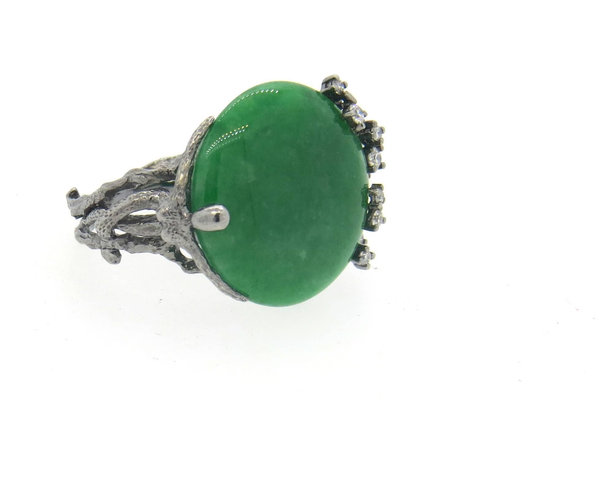 18k blackened white gold naturalistic ring, featuring 12.4ct natural green jadeite jade cabochon as a centerpiece, surrounded with approximately 0.30ctw in diamonds. Ring is a size 8, top measures 19mm x 25mm. marked 750. Weight of the piece - 9.3