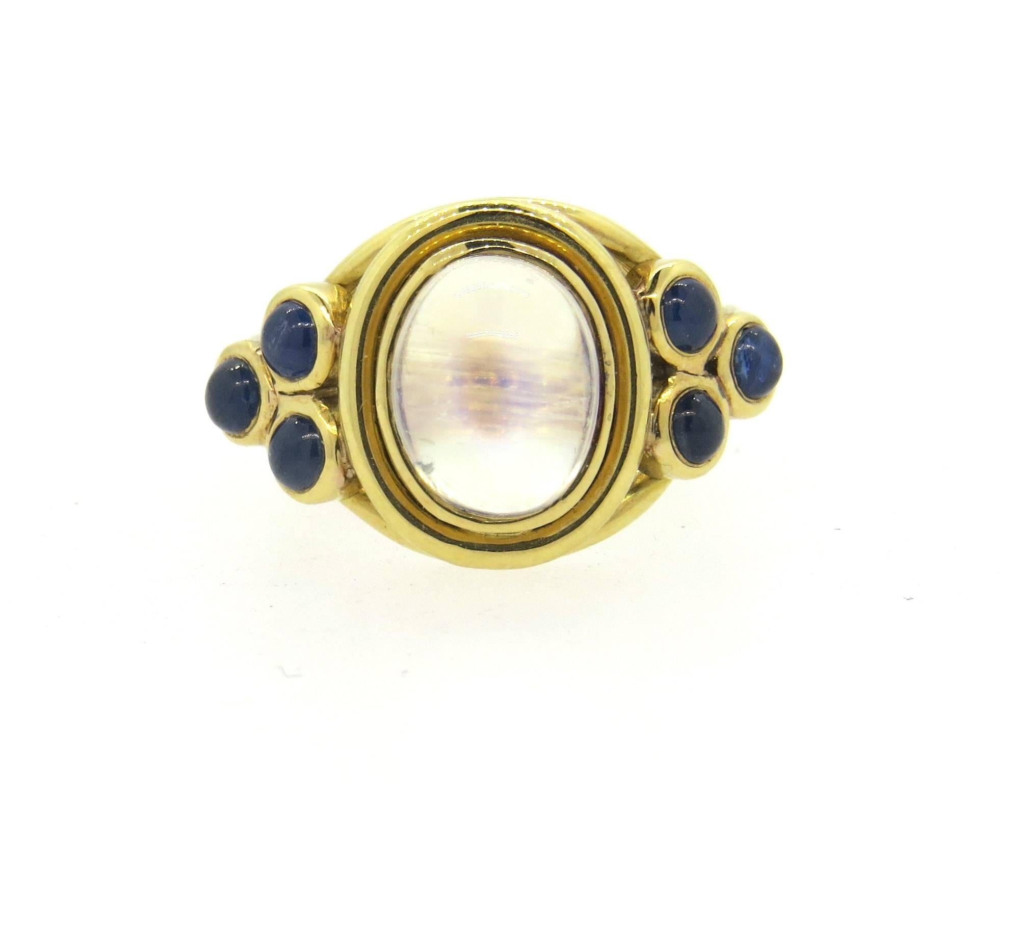 New 18k yellow gold ring, crafted by Temple St. Clair for Paolo collection, featuring blue sapphire cabochons and moonstone as a centerpiece. Ring is a size 6 1/4, ring top is 14mm wide. Marked with Temple mark and 750. Weight - 9.6 grams
Retails