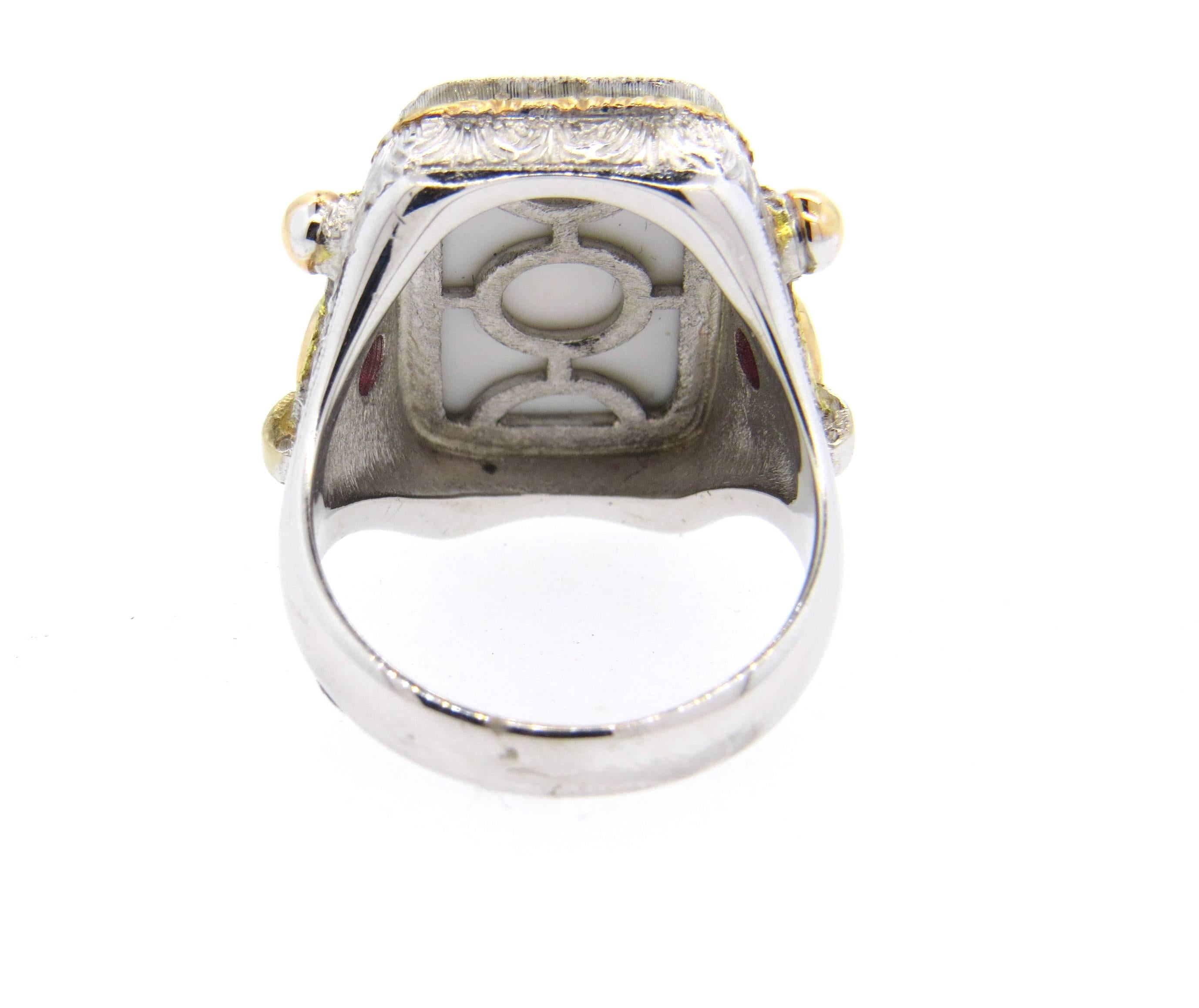 Large Cazzaniga ring, crafted in rose, white and yellow gold, set with green hardstone intaglio and two side rubies. Ring size 8, ring top is 21mm x 21mm. Marked: Cazzaniga, Roma, 750. Weight of the piece - 18.4 grams 