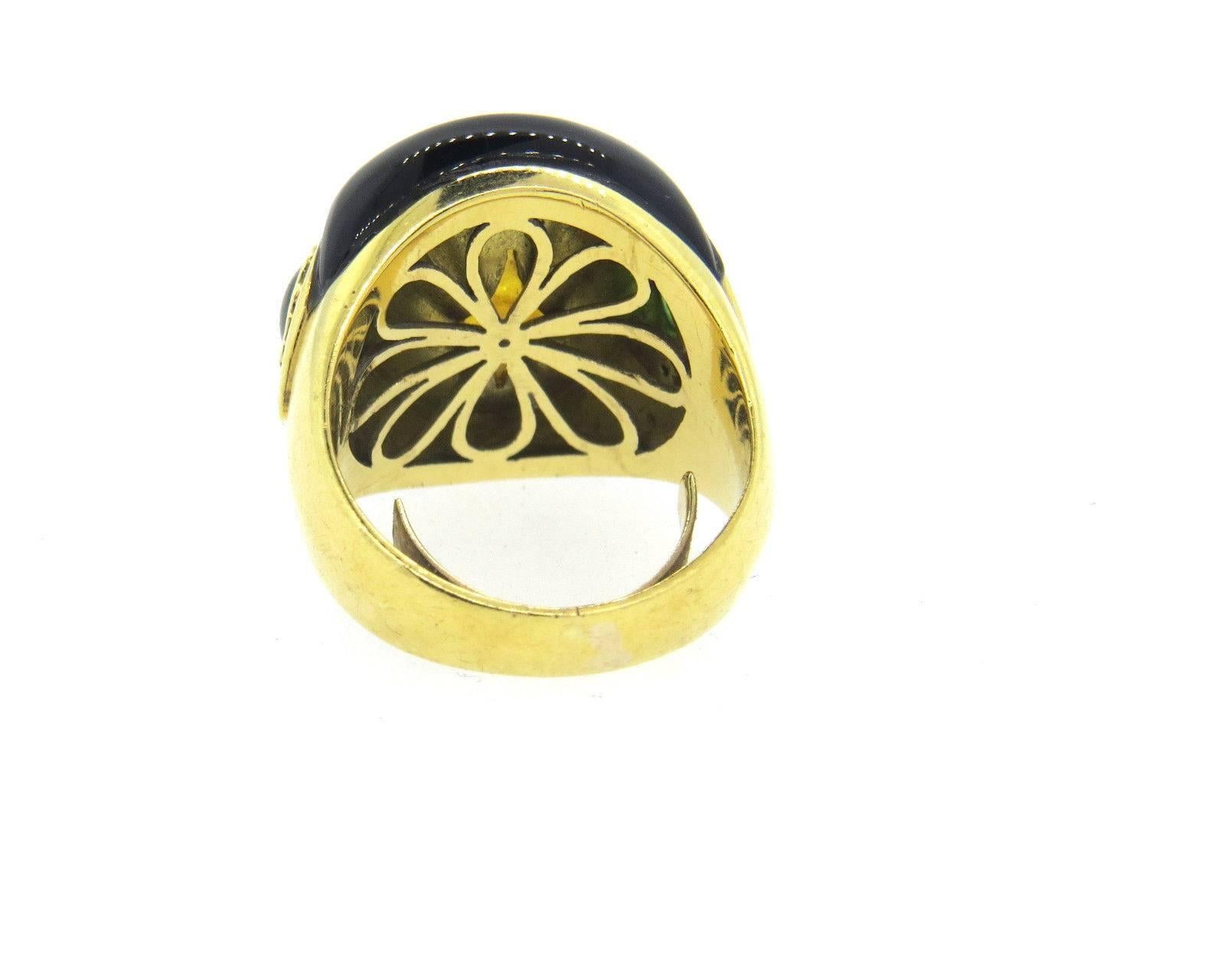 An 18k yellow gold cocktail ring adorned with a carved citrine, onyx, emeralds and diamonds.  The ring is a size 5 and the top of the ring is 18mm x 20mm.  The weight of the piece is 14.9 grams.