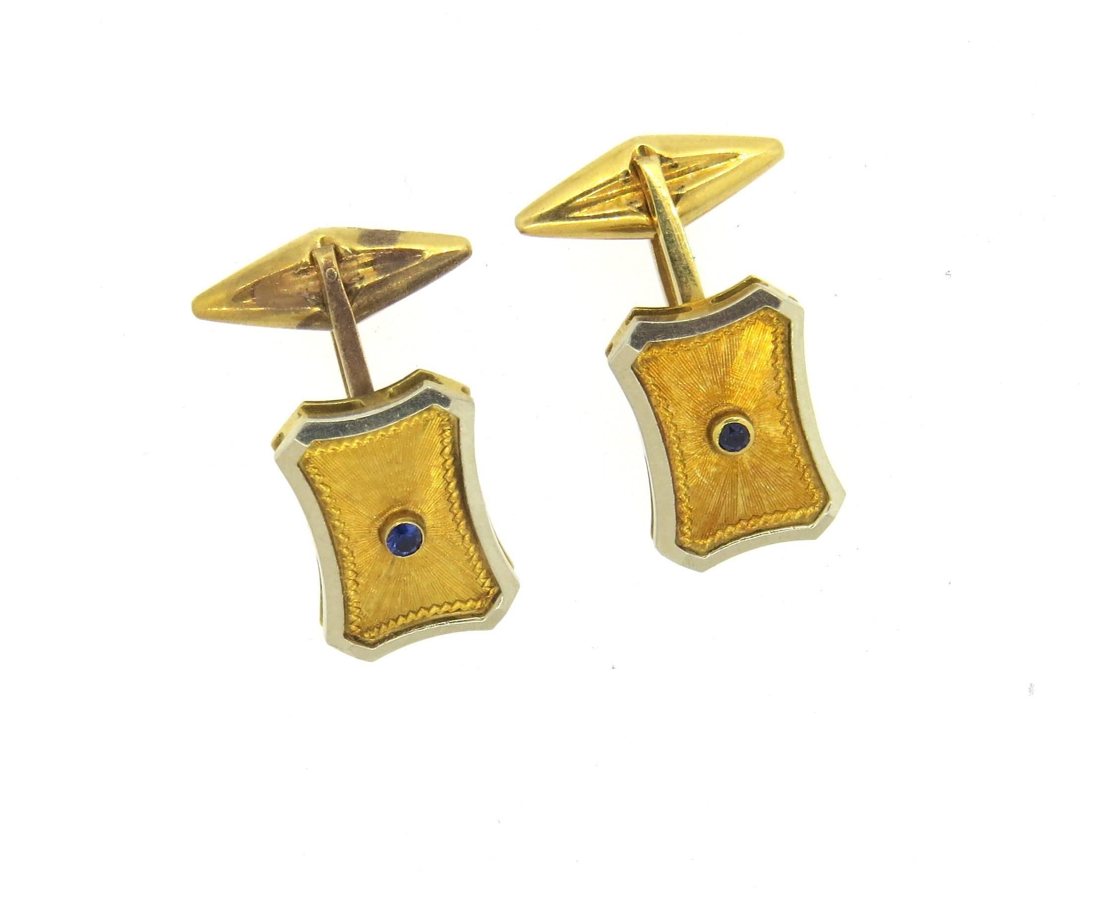 Pair of 18k white and yellow gold cufflinks, set with blue sapphires in the center. Each top measures 17mm x 12mm. Marked 750. Weight - 7.7 grams 