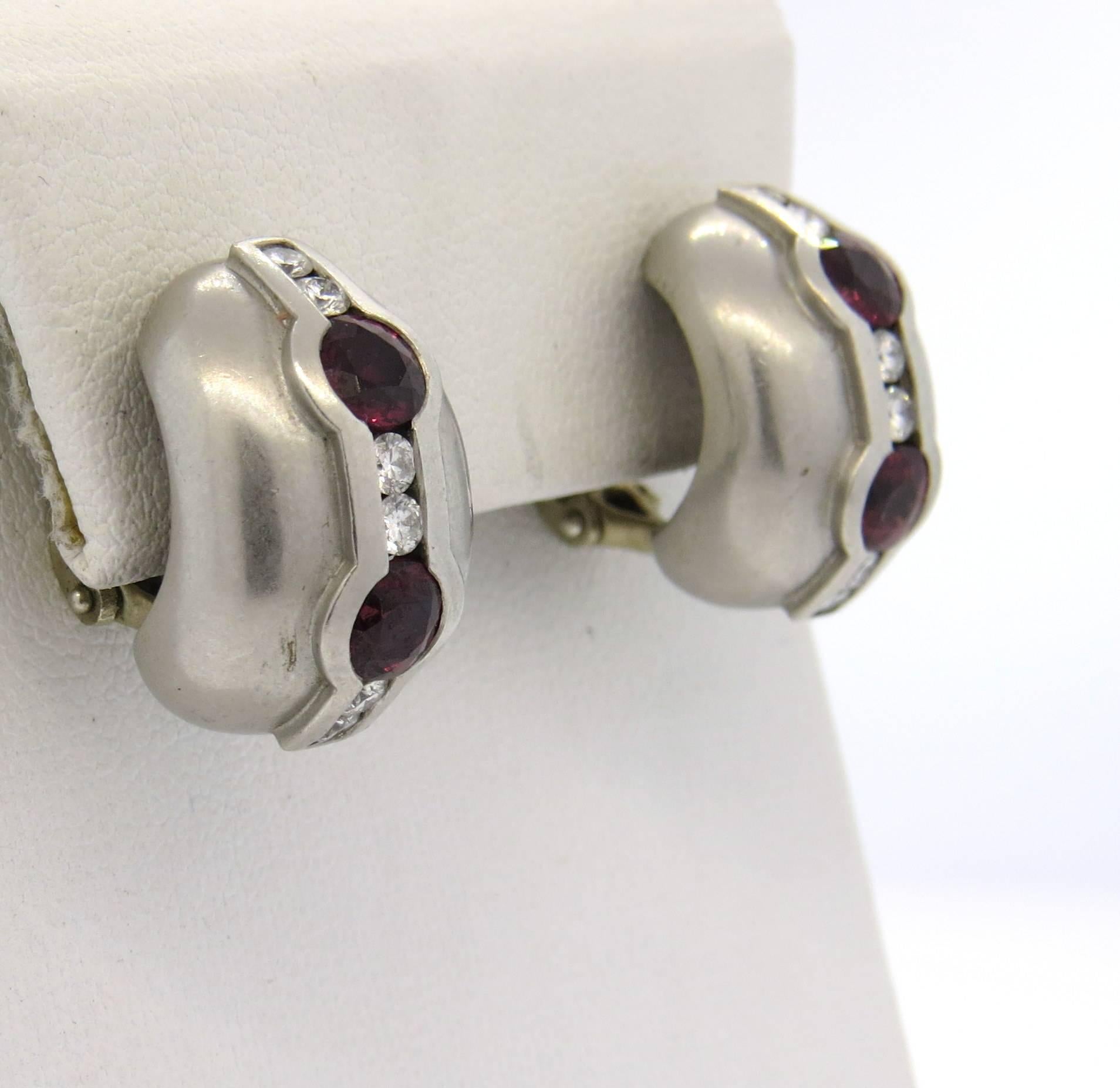 A pair of platinum earrings, crafted by Kieselstein Cord, featuring two ruby gemstones each, surrounded with a total of approx. 0.48ctw in G/VS diamonds. Earrings are 20mm x 13mm. Marked:plat, Kieselstein Cord, makers mark,1997. Weight - 25.9 grams 