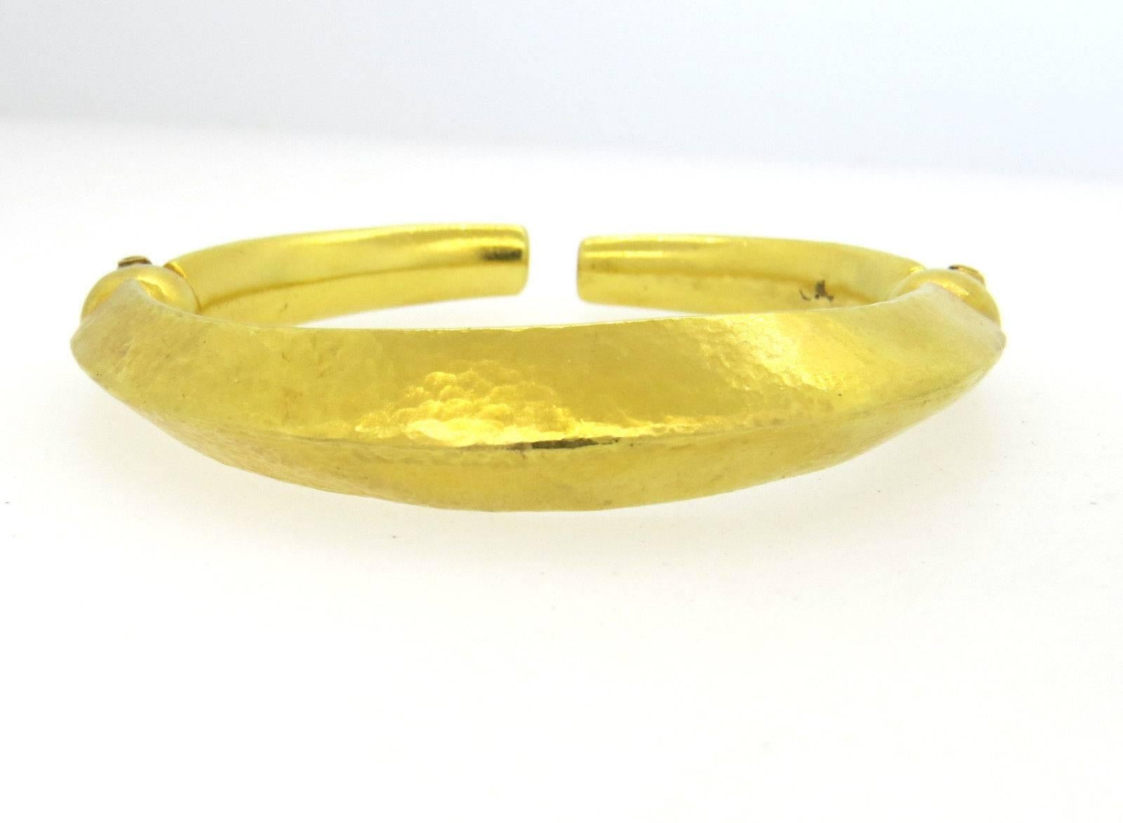 An 18k yellow gold cuff bracelet in a hammered finish.  Crafted by Ilias Lalaounis the bracelet will fit up to a 7