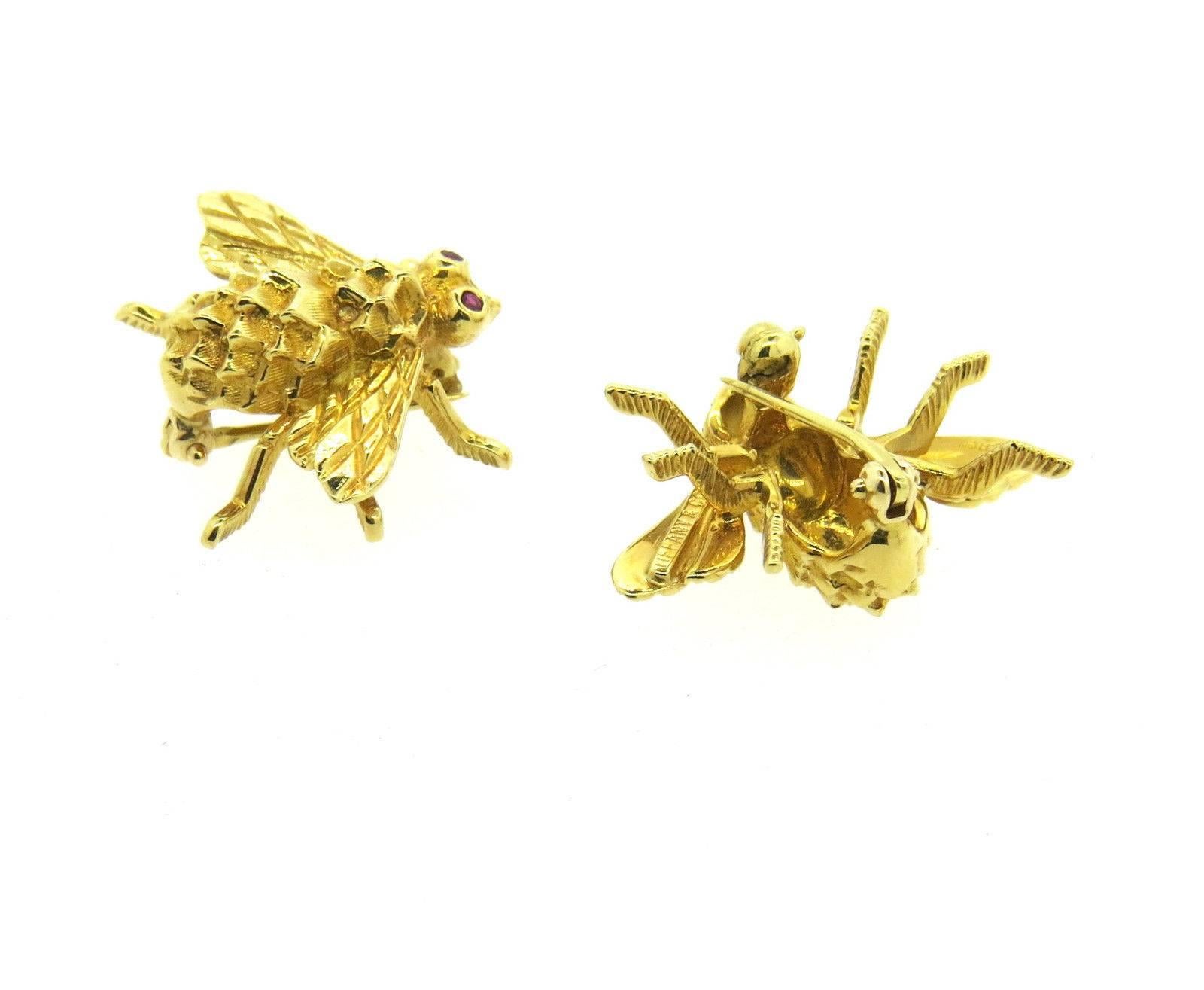 A pair of 18k yellow gold bumble bee brooch pins with ruby eyes.  Crafted by Tiffany & Co, each pin measures 18mm x 25mm.  The total weight of both pins is 10 grams.  Marked: 18Kt, Tiffany & Co 
