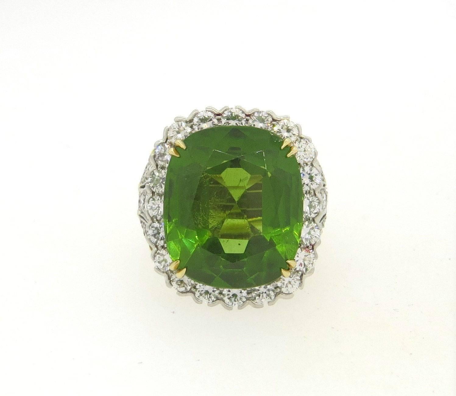 An 18k yellow gold and platinum ring set with a 25.28ct peridot and 3.71ctw of G/VS diamonds.  Crafted by David Webb, the ring is a size 6 1/4, ring top is 25mm x 22mm, sits approx. 12mm from the finger.   Marked: David Webb 900pt, 18k.  The weight