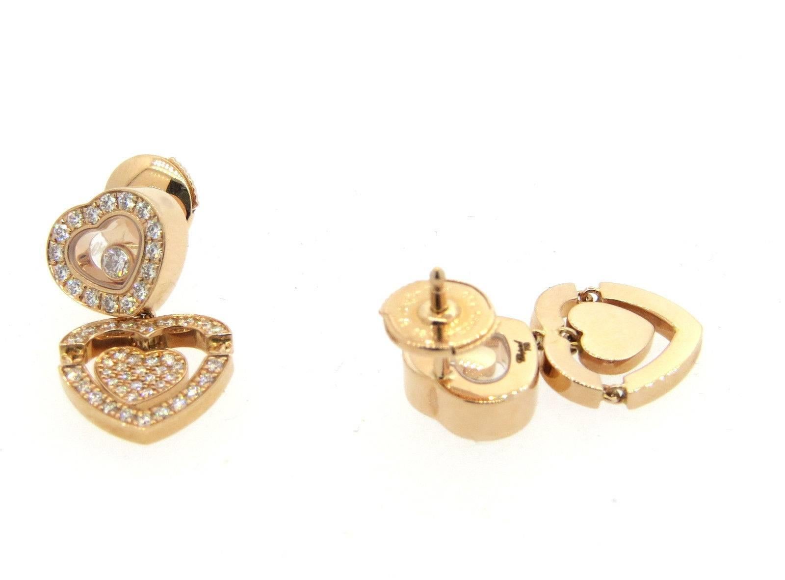 A pair of 18k rose gold earrings set with approximately 0.73ctw of F/VVS diamonds.  Crafted by Chopard, the earrings measure 21mm long x 12mm wide. The bottom heart elements are movable. Marked:	Chopard, 750, 6197561, 837219-5002.  The weight of the
