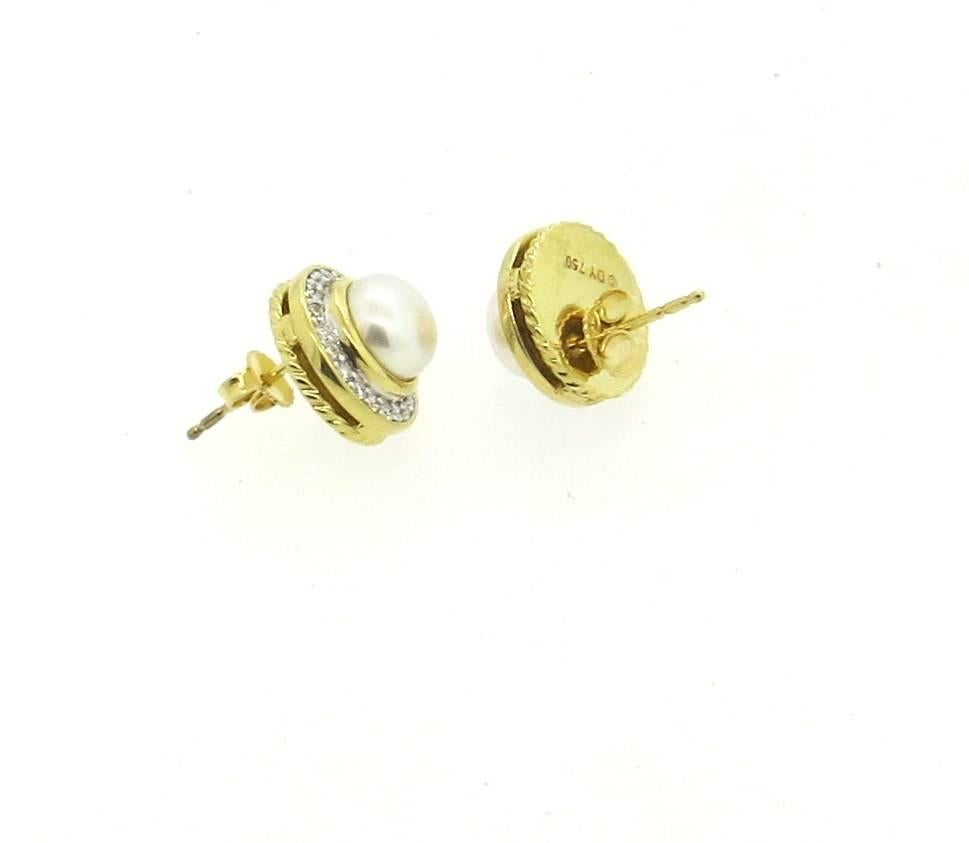 A pair of classic 18k gold stud earrings, crafted by David Yurman, set with 8mm pearls, surrounded with approx. 0.45ctw in diamonds. Earrings are 13.5mm in diameter. Marked: D.Y. 18k . Weight - 10.3 grams 