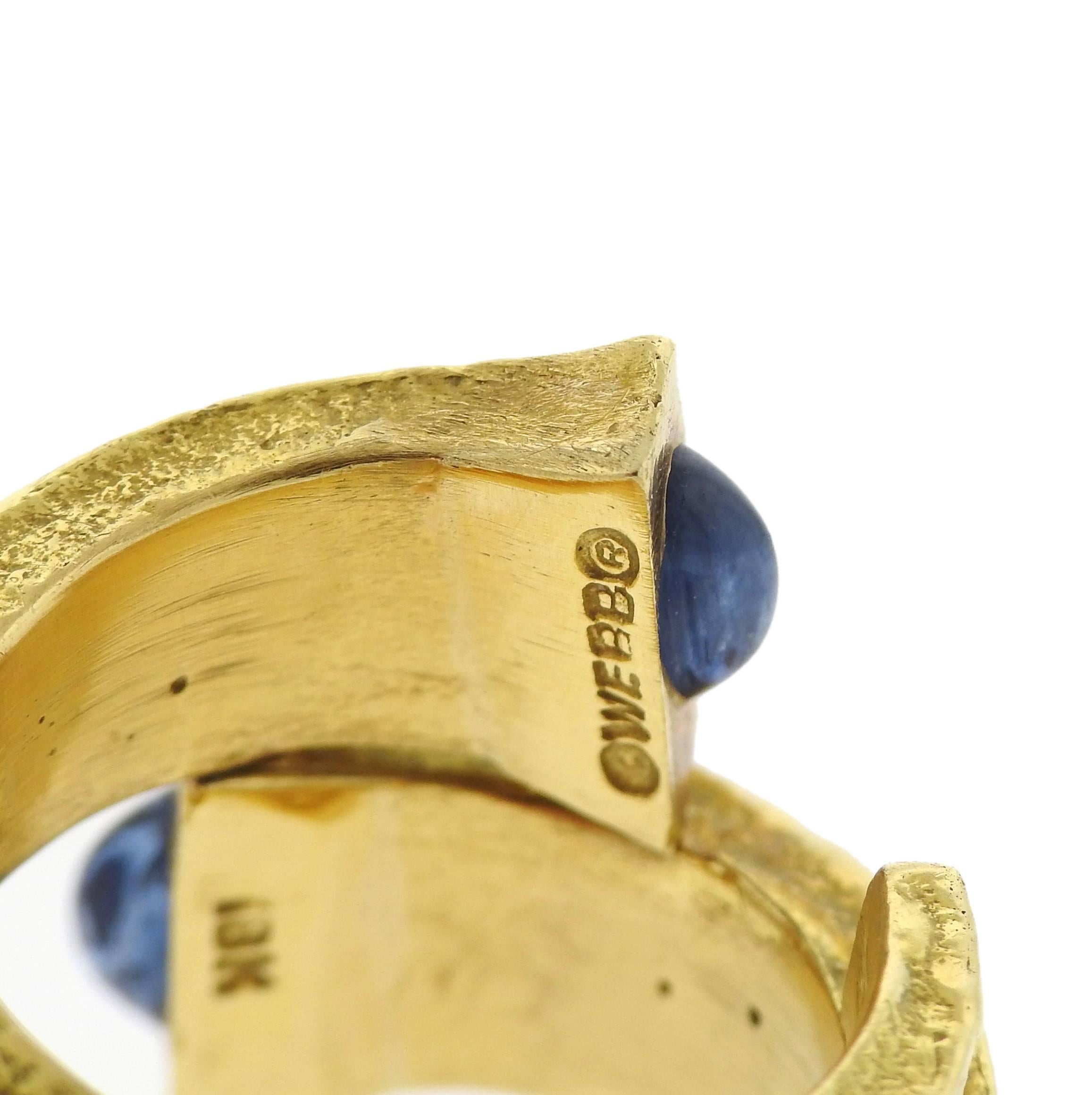 An 18k yellow gold ring, featuring wrap around nail design, adorned with blue sapphire cabochons. Crafted by David Webb, Ring size - 6 1/4, ring top is 20mm at widest point. Marked: Webb, 18k. Weight of the ring - 26.1 grams