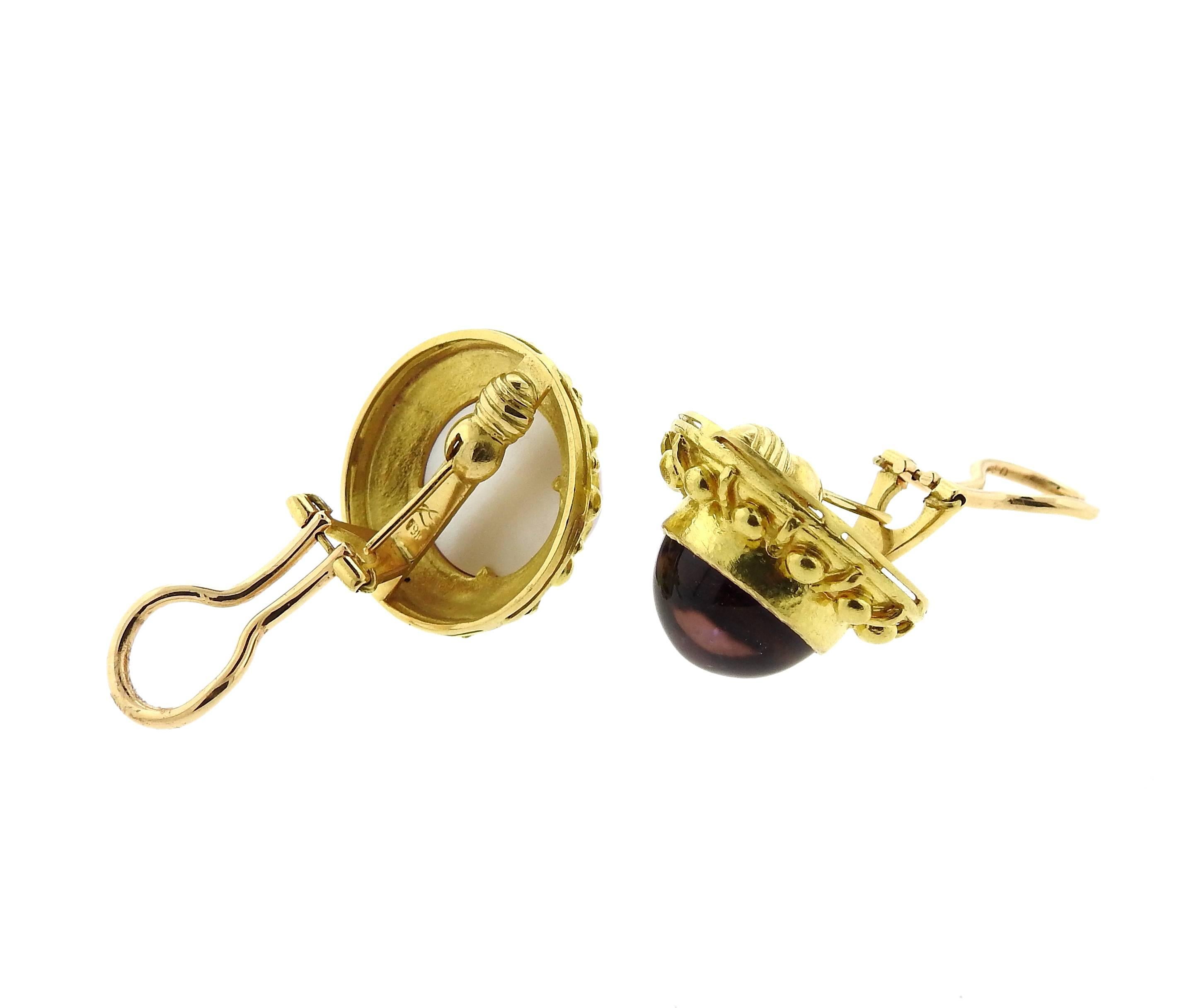A pair of 19k gold earrings, crafted by Elizebath Locke, set with 14mm amethyst cabochons, backed with mother of pearl. Earrings are 23mm in diameter. Marked with Locke E mark and 19k. Weight - 25.6 grams 