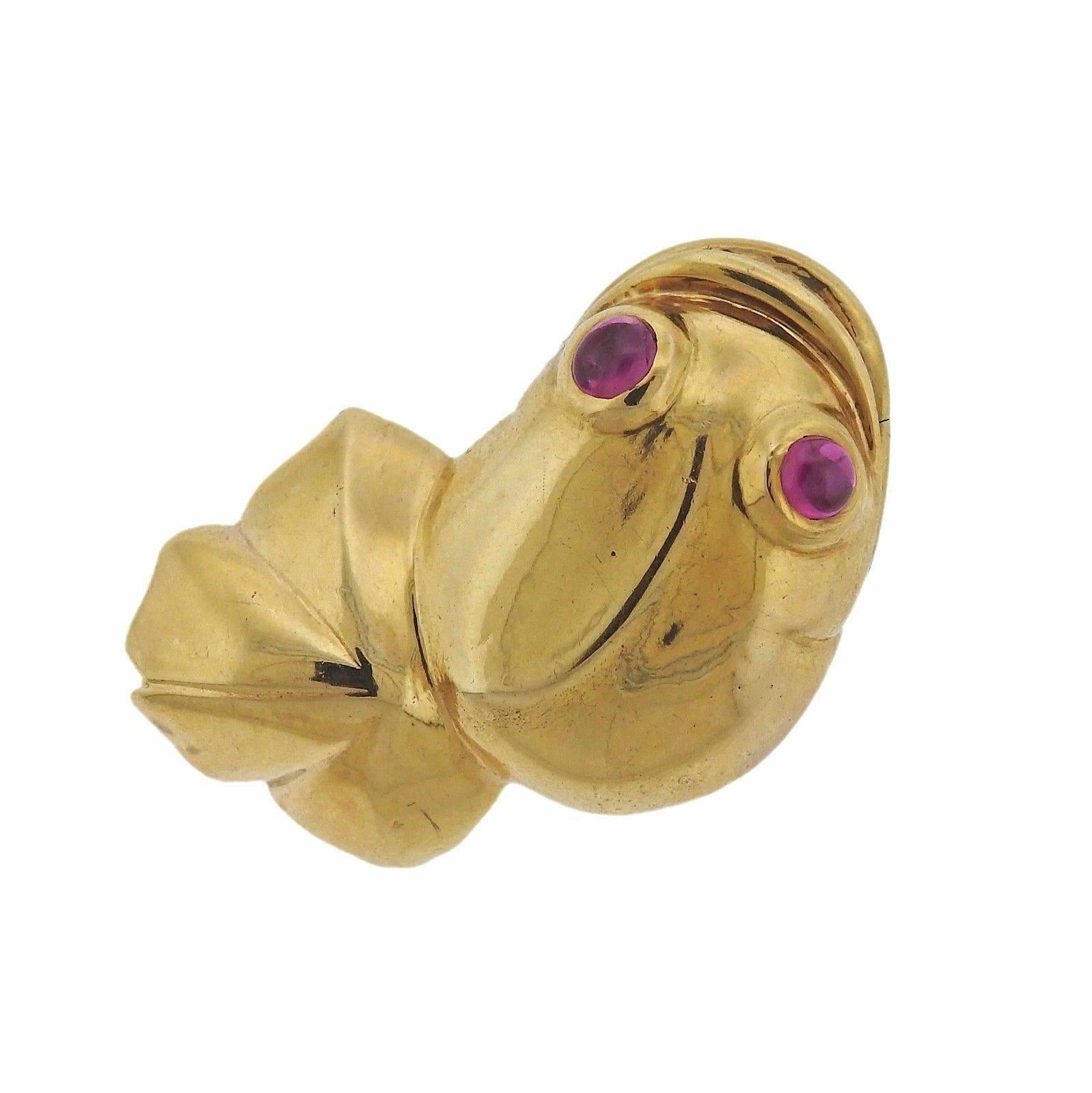 A 14k yellow gold fish brooch set with pink gemstone eyes and diamond teeth.  The brooch measures 47mm x 28mm and weighs 19.6 grams.  Marked: Seaman Schepps.