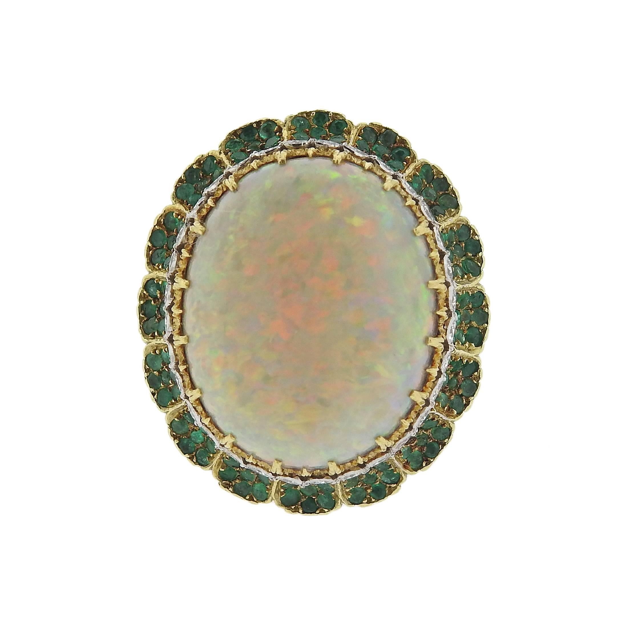 Impressive 18k yellow gold cocktail ring, crafted by Buccellati, set with opal cabochon - measuring 20.2mm x 16.4mm, surrounded with emeralds and  diamonds. Ring is a size 4 1/2 (sizing balls can be removed to increase the size), top measures 26mm x
