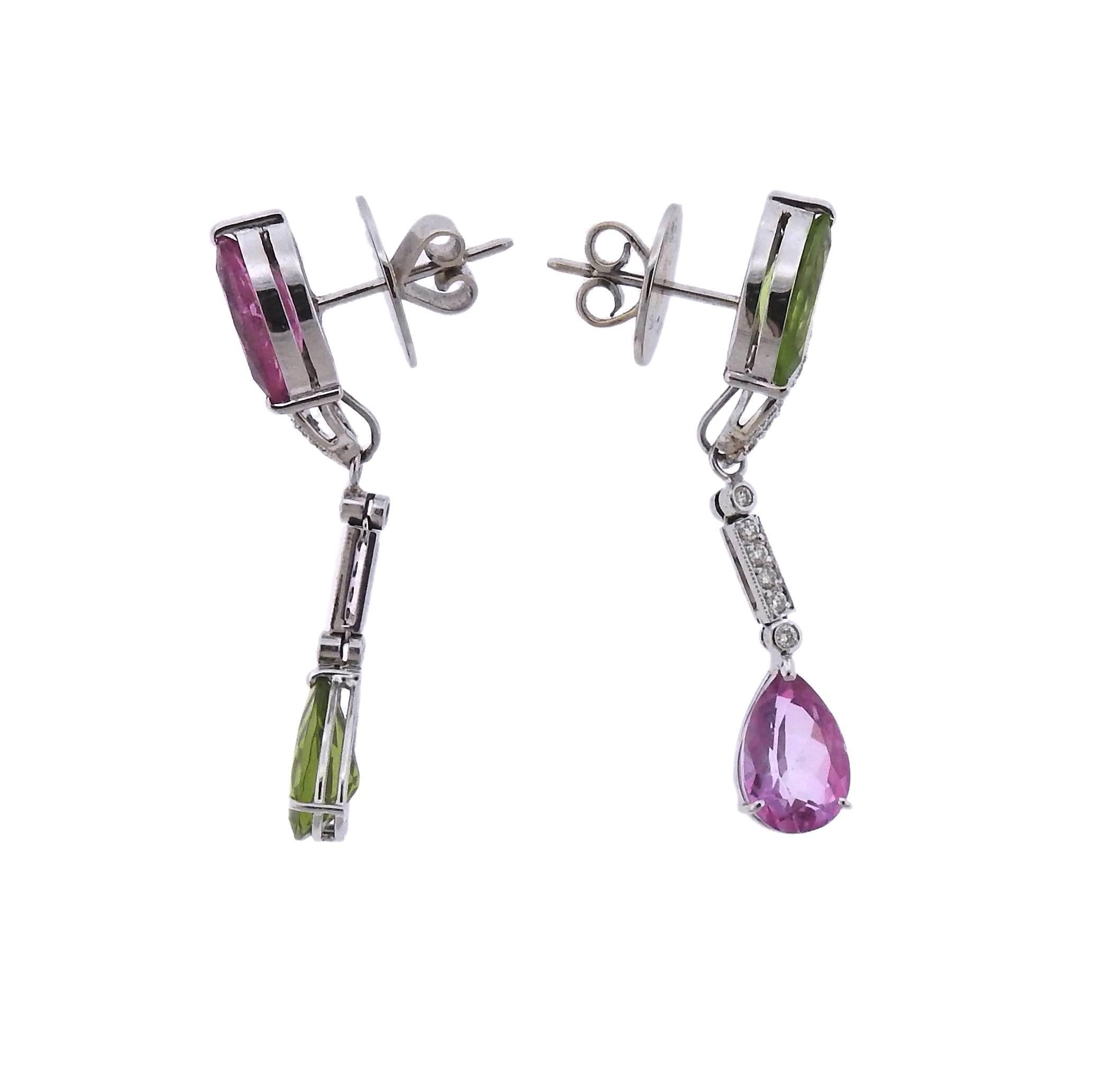 A pair of 14k white gold day & night earrings, set with approximately  0.60ctw,  peridots and pink sapphires.  Come with removable interchangeable drops. Earrings are 47mm long with drops attached, and 20mm without.  Marked 585. Weight - 14.9