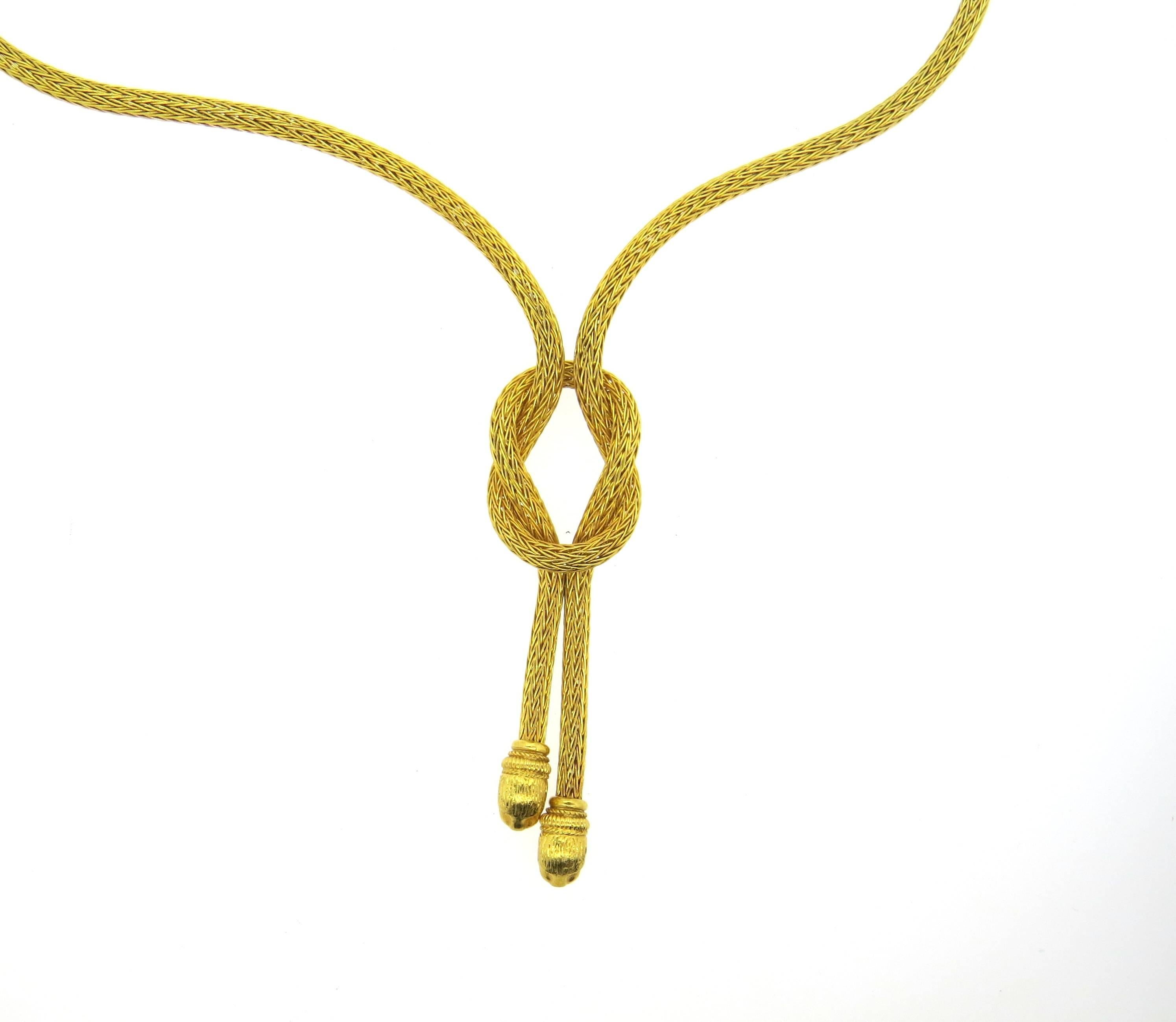 18k yellow gold necklace, crafted by Ilias lalaounis, featuring a knot with two chimera heads on the ends. Necklace's wearable length is 19