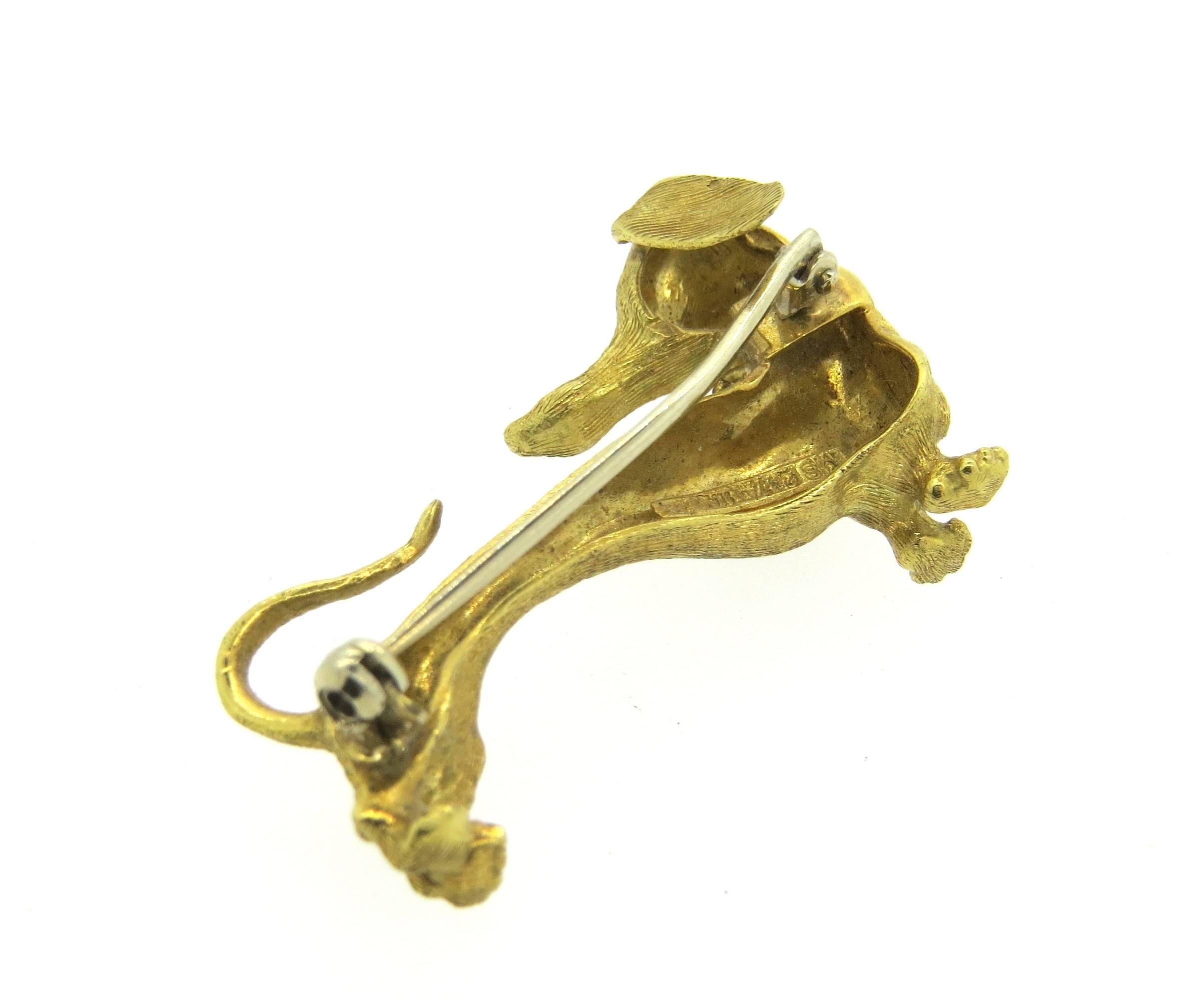 18k brushed yellow gold Dachshund dog brooch, decorated with a ruby eye. Brooch measures 36mm x 20mm. Weight of the piece - 9.6 grams