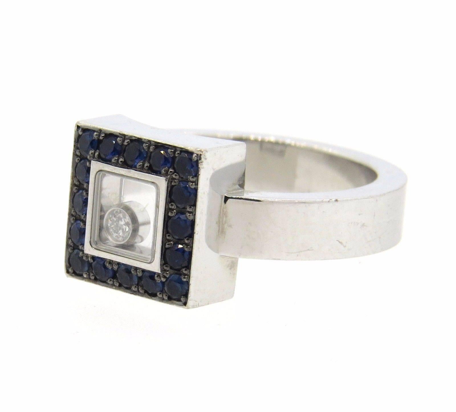 18k white gold square top ring, crafted by Chopard for Happy Diamonds collection, featuring blue sapphire top and signature floating diamond in the center. Ring size 6.75, measures 10mm at widest point. Marked: Chopard, 750, 2667731, 82/2896/3-20.