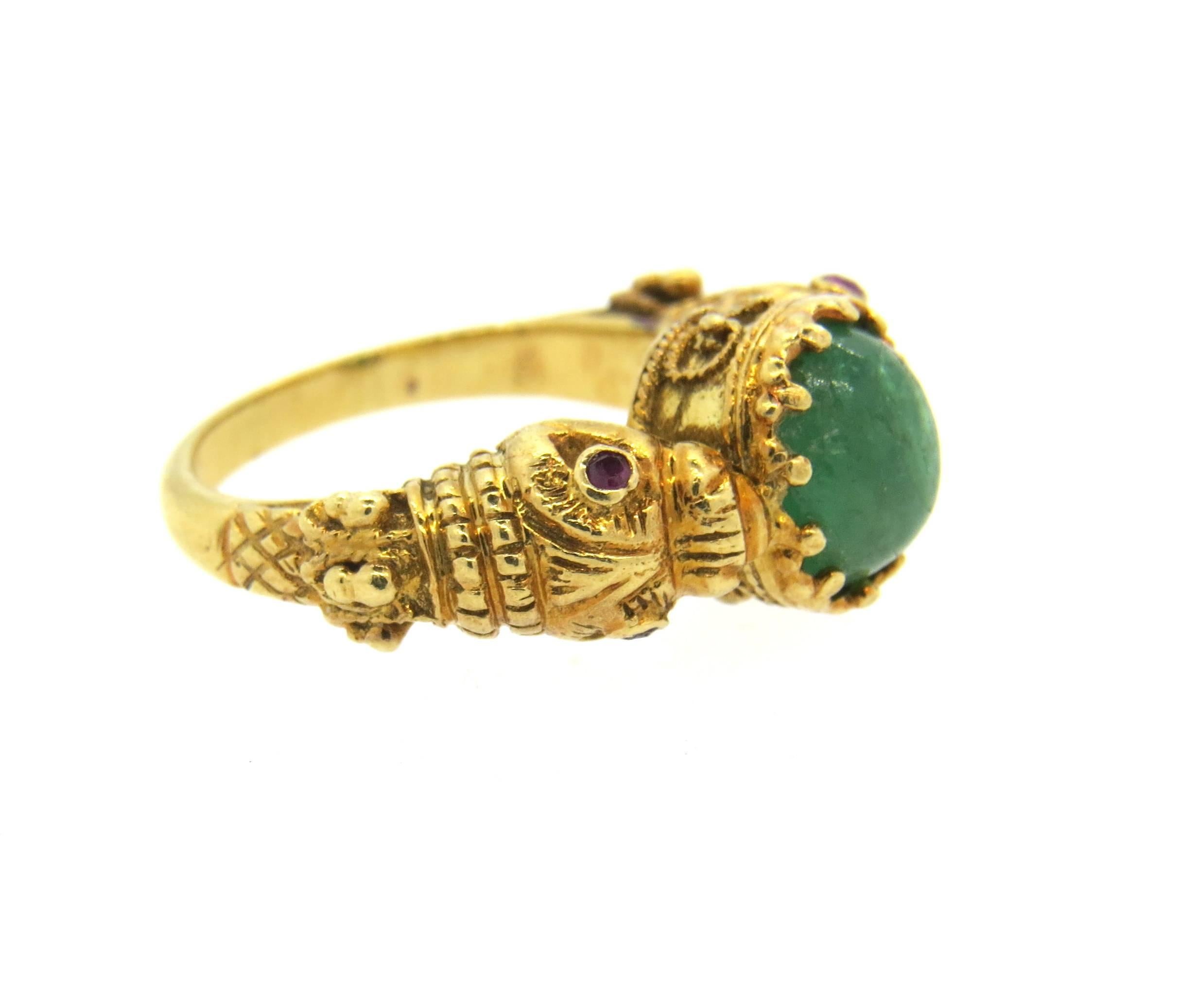 18k yellow gold ring, crafted by Zolotas, set with 8.7mm x 7.5mm emerald as a centerpiece, surrounded with four rubies. Ring is a size 5 1/2, ring top is 9.7mm wide.   Marked: 750, Zolotas mark. Weight of the piece - 10.4 grams