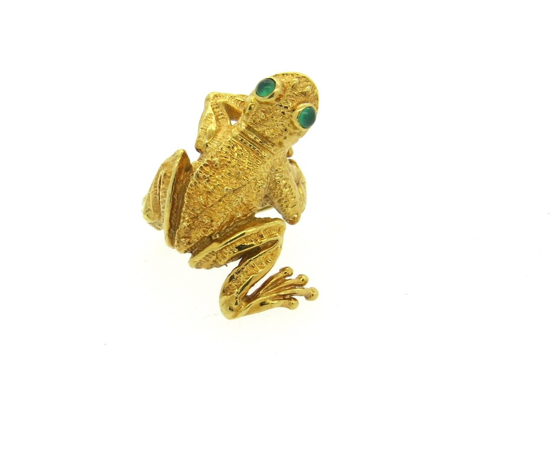 Whimsical circa 1970s 18 yellow gold frog ring, crafted by Kurt Wayne, decorated with emerald cabochon eyes. Ring is a size 4 3/4, ring top is 29mm x 20mm. Marked KW, 1970, k18. Weight of the piece - 15.4 grams