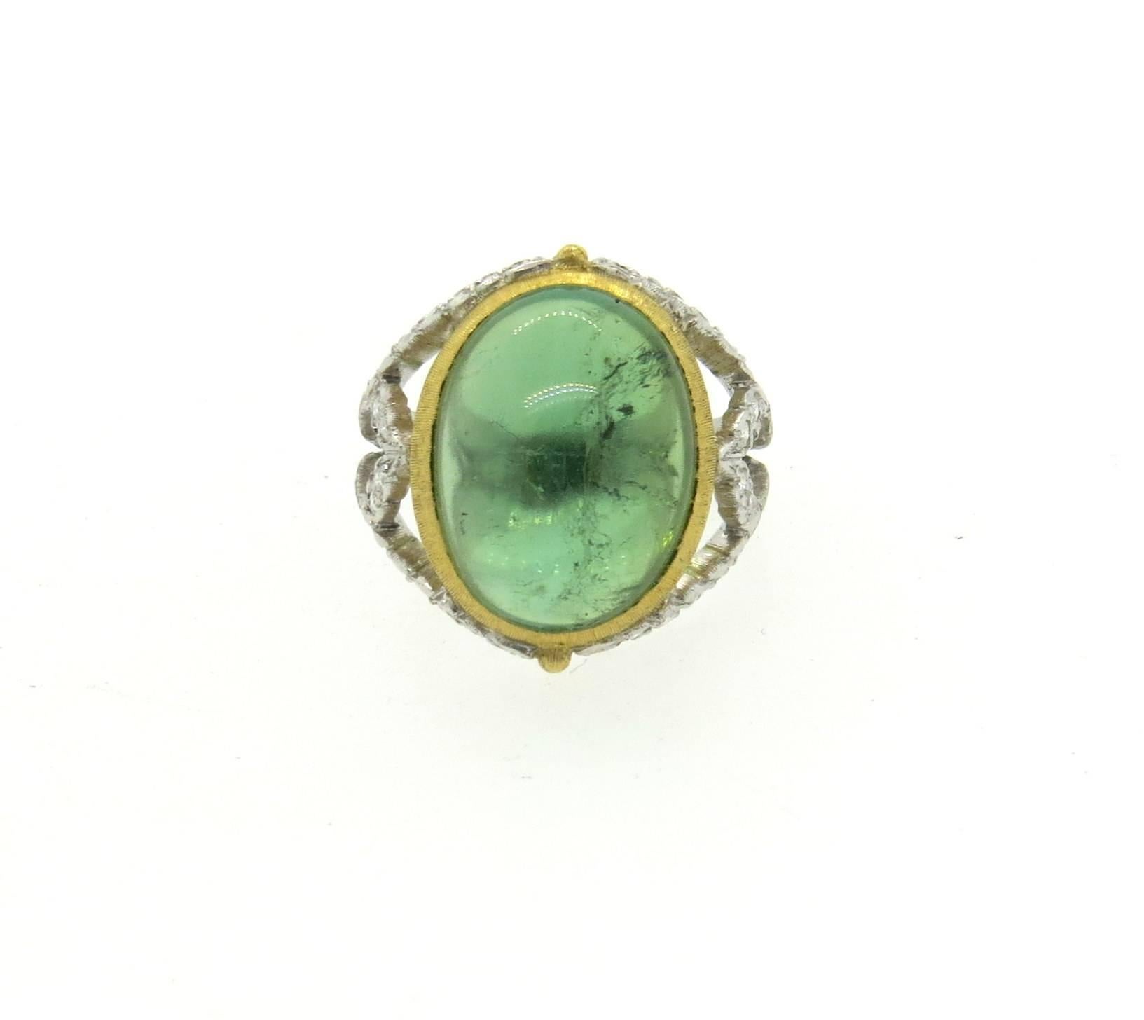 18k yellow and white gold ring, crafted by Buccellati, crafted with an approximately 13-13.5ct green tourmaline cabochon, surrounded with approx. 0.50ctw in diamonds. Ring is a size 6 1/4m ring top is 19mm wide. Marked: Buccellati,18Kt, Italy.