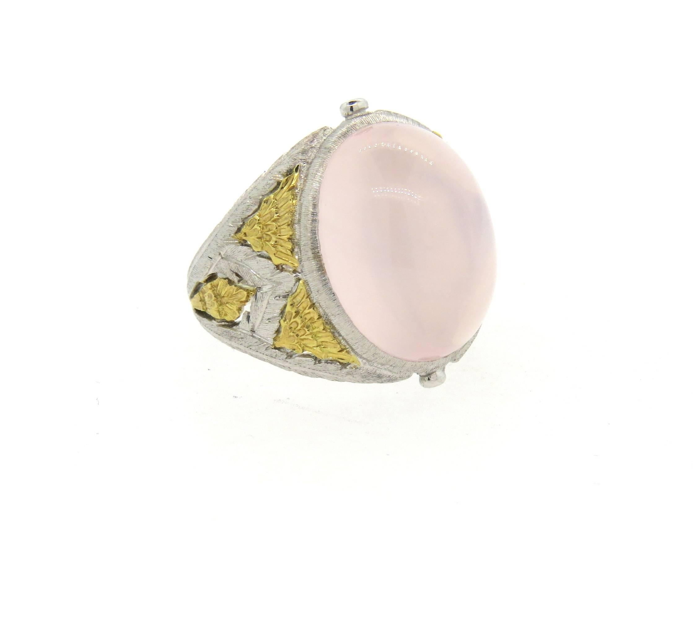 18k white and yellow gold dome ring, crafted by Buccellati, set with an approximately 11.5ct rose quartz cabochon as a centerpiece. Ring is a size 6 1/2, ring top is 19mm wide. Marked 750, Buccellati, Italy. Weight of the piece - 9.2 grams 
Comes