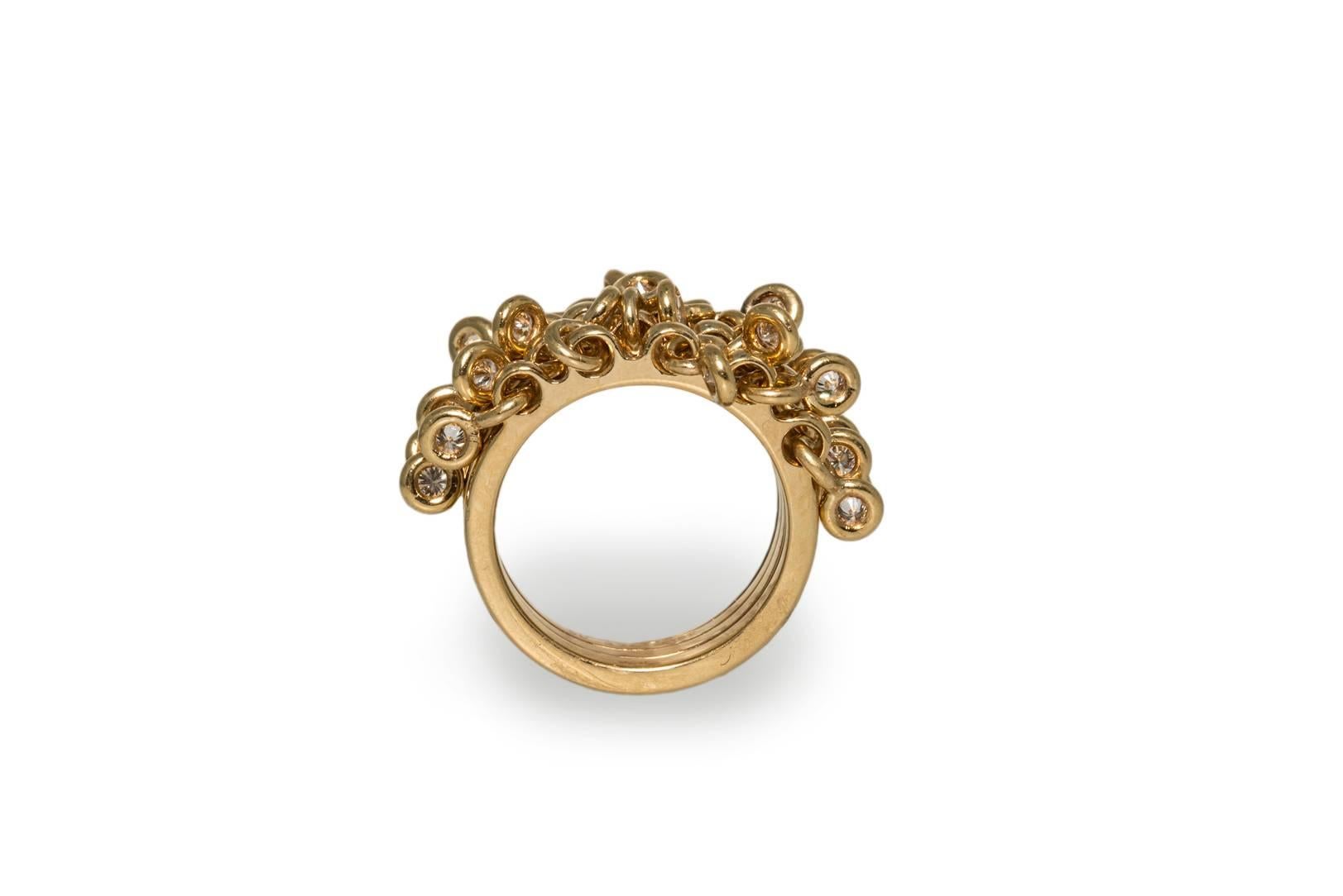 This Dior ring is set in 18k yellow gold. It is designed as five fused bands holding 25 round, brilliant cut, bezel set diamonds in suspended loops. The diamond weight is 1 ct. E-F-G colour, VVS-VS clarity. The ring is stamped on the back of the