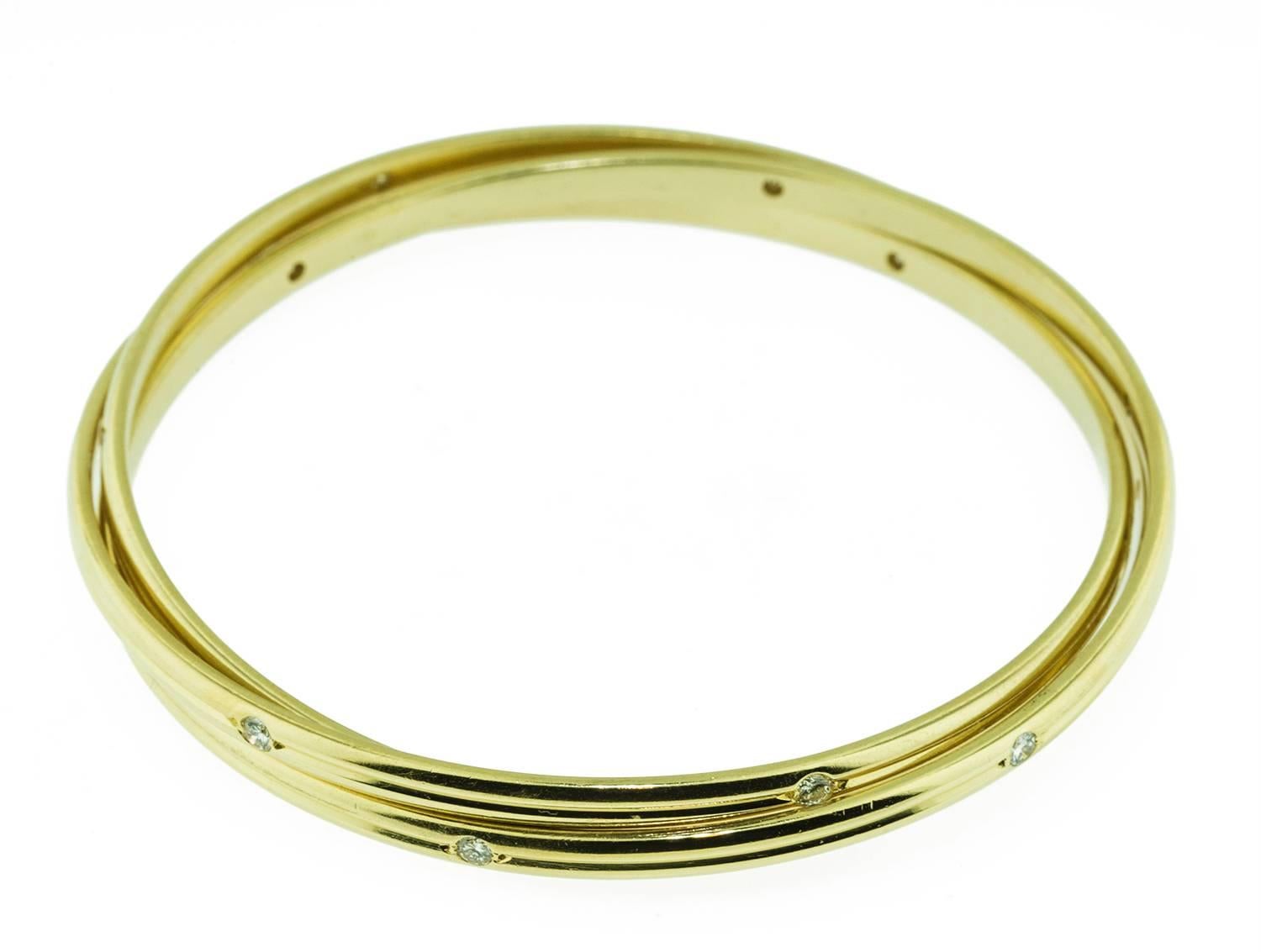 This bracelet is 18k yellow gold and stamped Cartier. It bares the registration mark B 4121. The ribbed yellow gold bangles hold eighteen high quality diamonds totaling 1 ct. The bangles were made in France approximately twenty five years ago. They