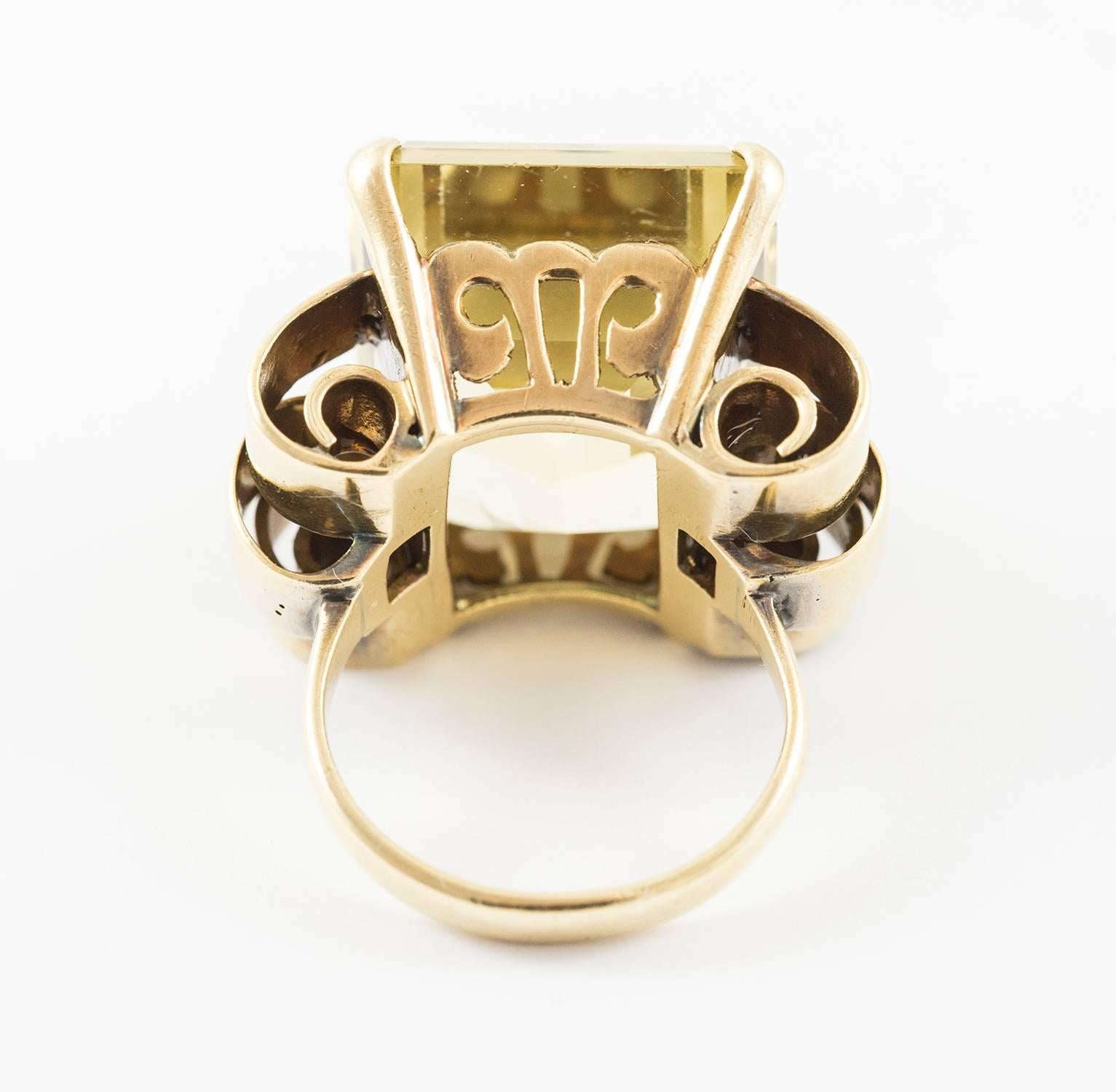 This dramatic ring is set in 18k yellow gold. It holds a 29 ct. bright, icy rectangular lemon quartz with a very good cut. The mount is custom made using a classic strong retro design, typical of the 1940's. This ring is bold and handsome. The ring