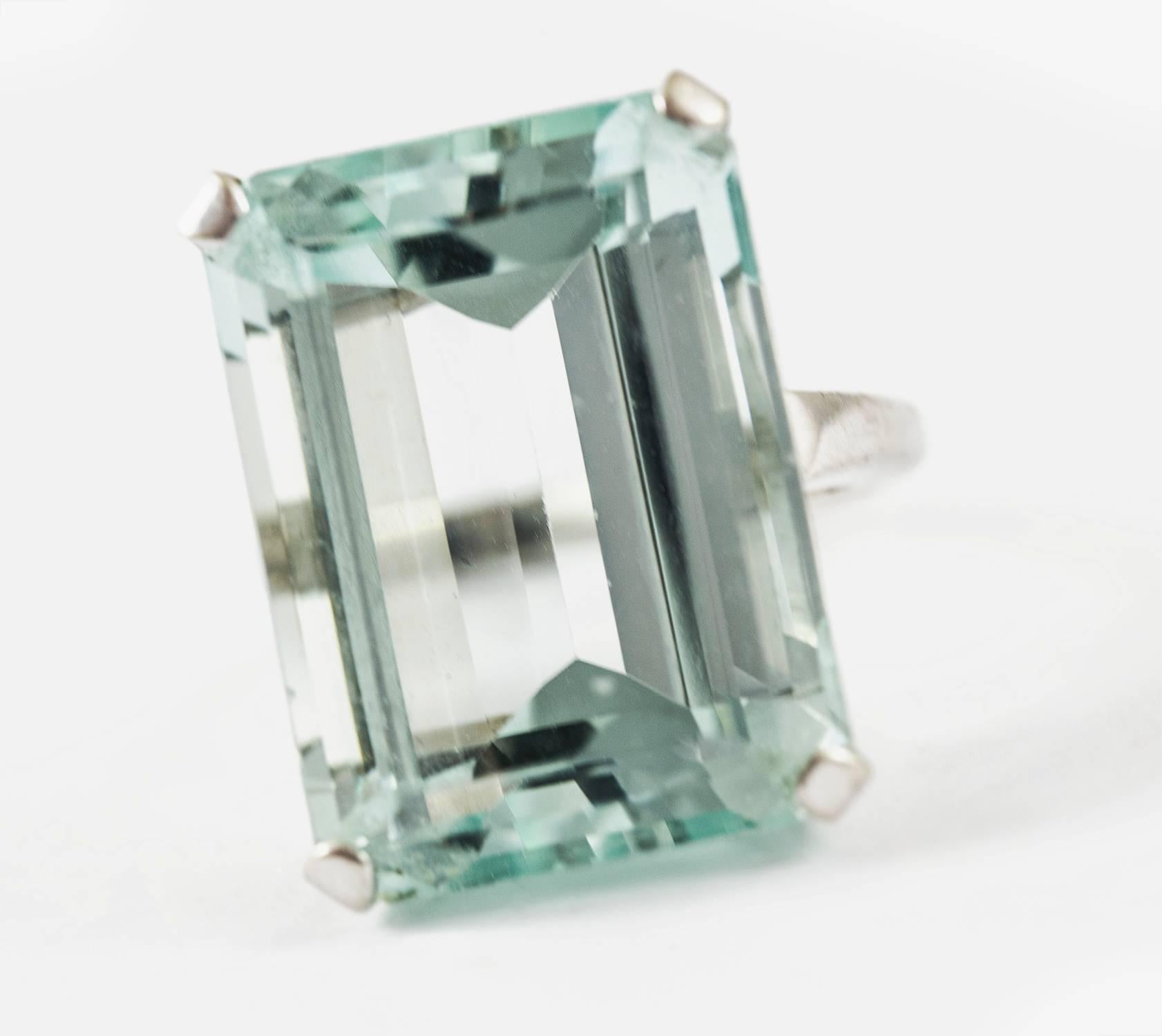 This fine aquamarine ring is set in 14k white gold. It holds an icy, transparent sparkling aquamarine, weighing 27 cts. The colour is classified as strongly greenish blue with a medium-light tone. It is eye clean. This ring is classic, elegant and