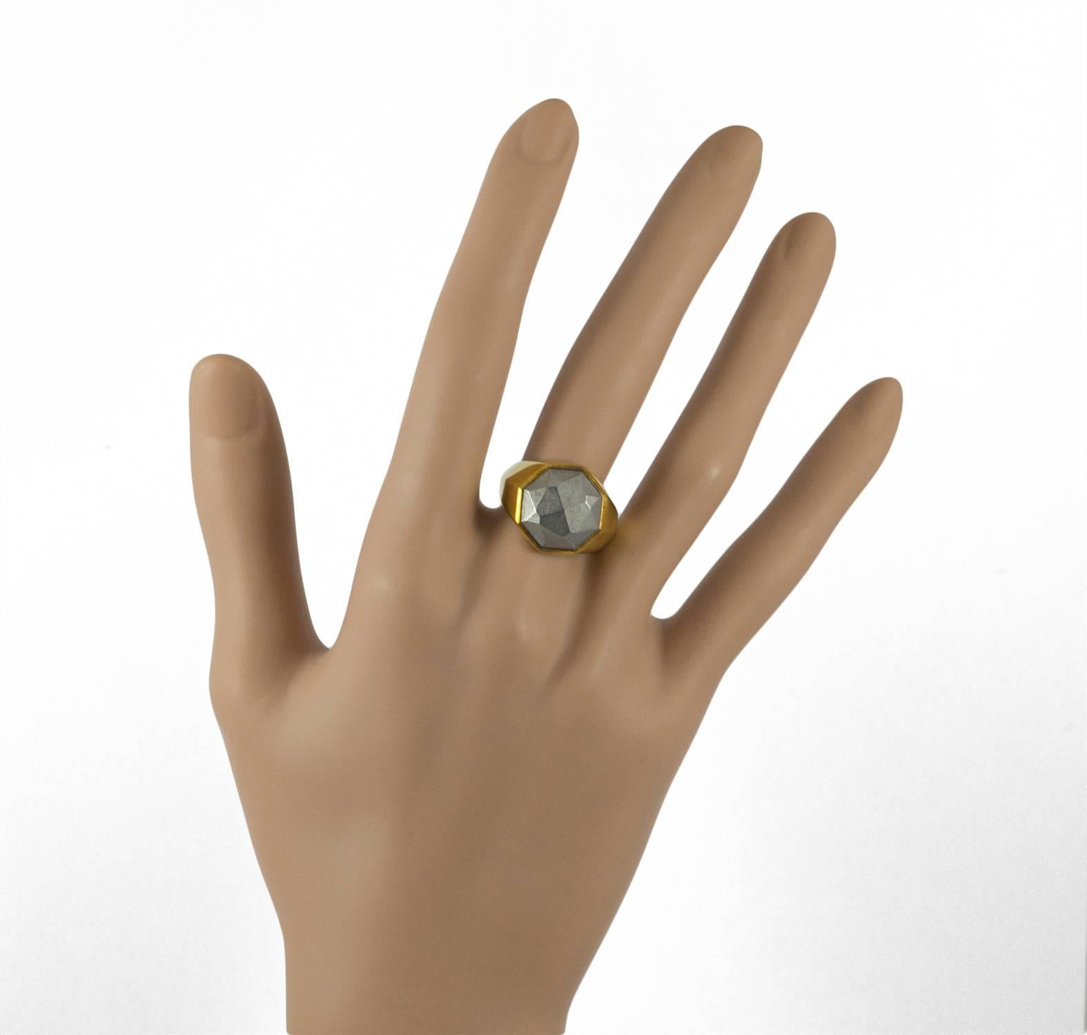 This unusual David Yurman ring is set in 18KT yellow gold. It bares the David Yurman signature and an additional mark indicating the collection. The ring is unique and set with a faceted piece of meteorite. it measures size 6.5 and would be a