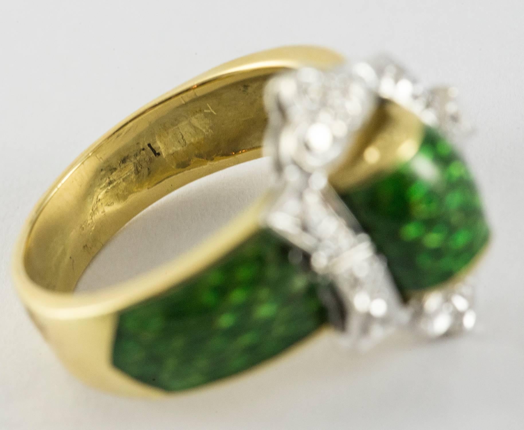 A beautiful enamel buckle ring set in 18k white and yellow gold. The front buckle is set in white gold with hand embellishment representing diamond detail. The green snake skin enamel representing the belt fabric is lush and detailed. This ring