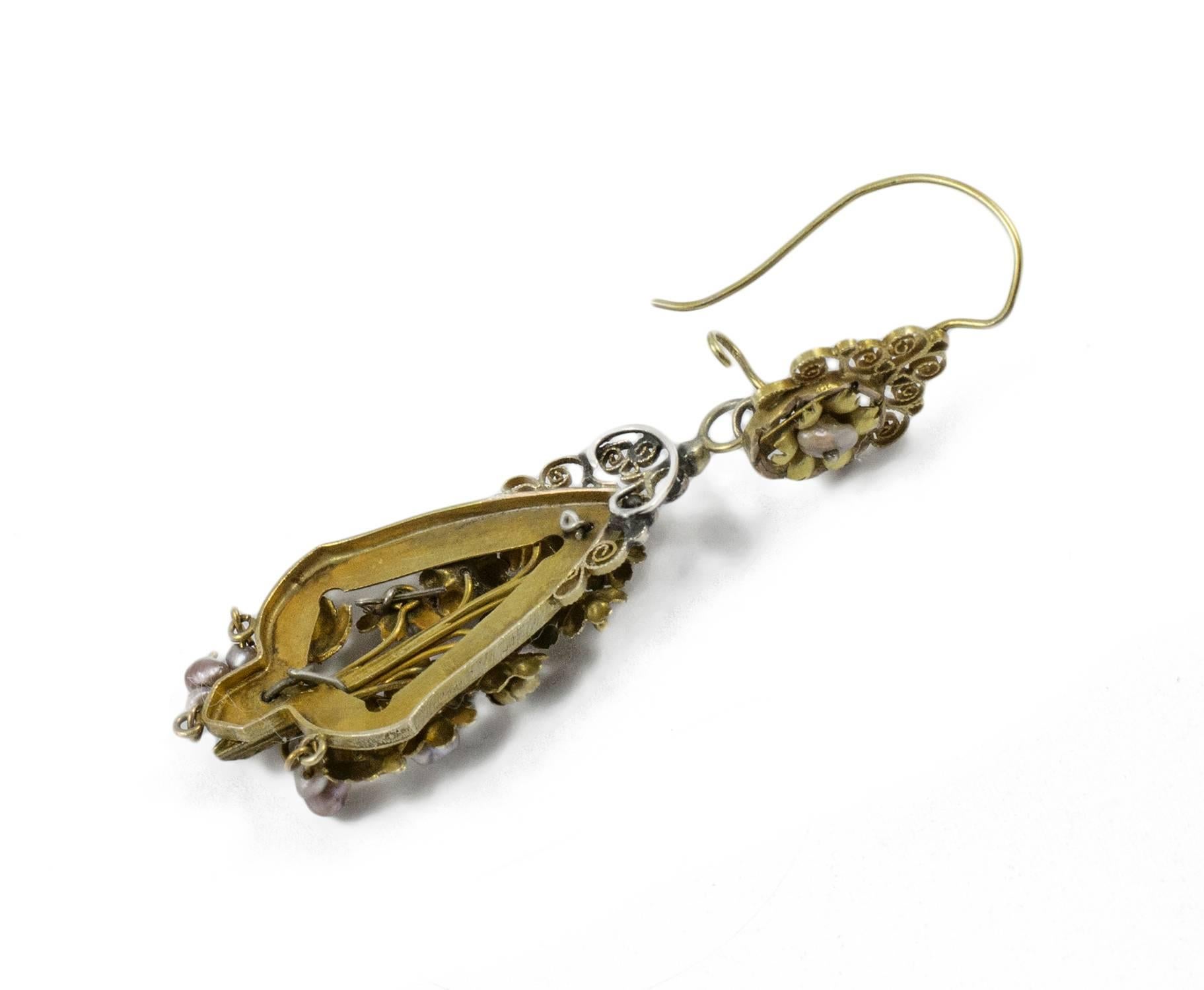 A exceptional pair of Antique 'Day and Night' earrings. Completely hand made in 12k gold designed with hand made gold flowers and foliage enhanced by tiny seed pearls. These earrings are all original. They measure approximately three inches from top